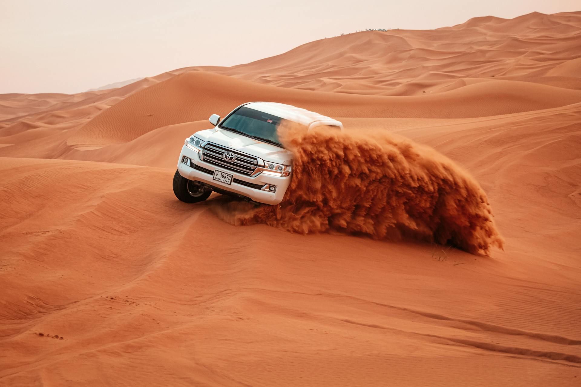 4x4 vehicle driving on sand dunes in dubai desert 4x4 vehicle driving on sand dunes in dubai desert