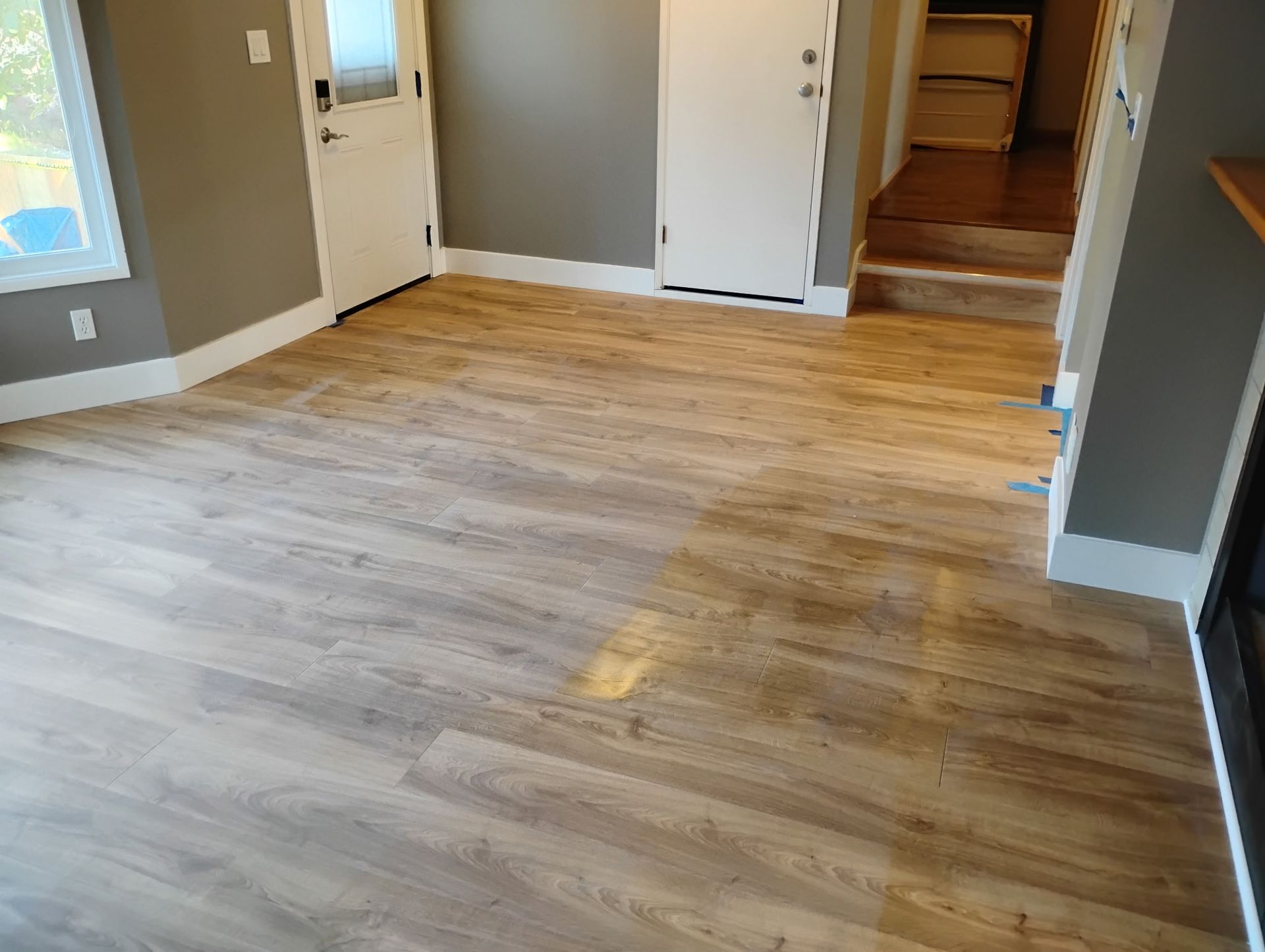 Finished, level, and cleaned laminate flooring paired with fresh baseboards. Finished, level, and cleaned laminate flooring paired with fresh baseboards.