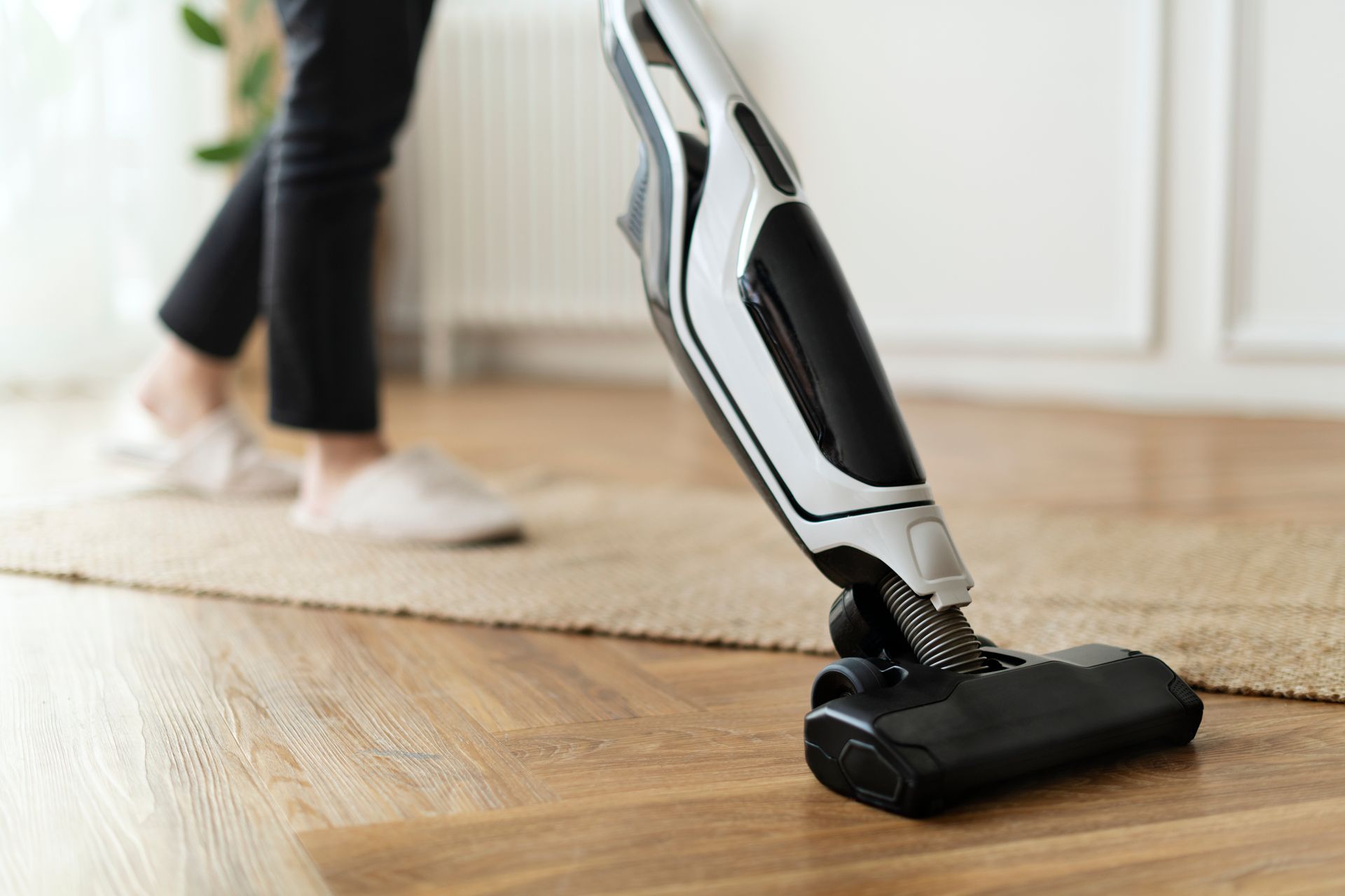femme tenant un aspirateur a main, qui aspire son parquet. femme tenant un aspirateur a main, qui aspire son parquet.