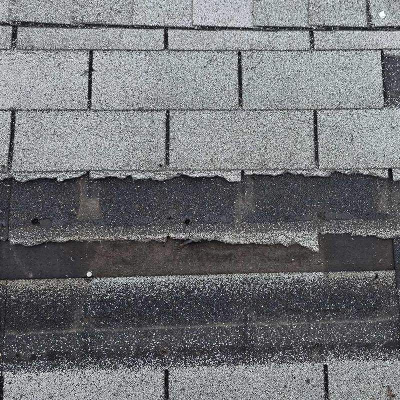 Torn-off shingles, underlayment showing