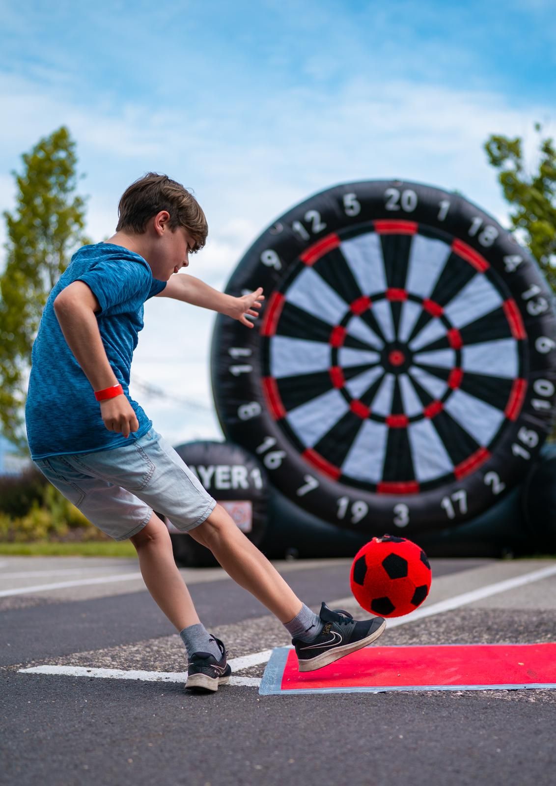 kind schiesst auf riesige fussball dartscheibe beim banner batterien sommerfest kind schiesst auf riesige fussball dartscheibe beim banner batterien sommerfest