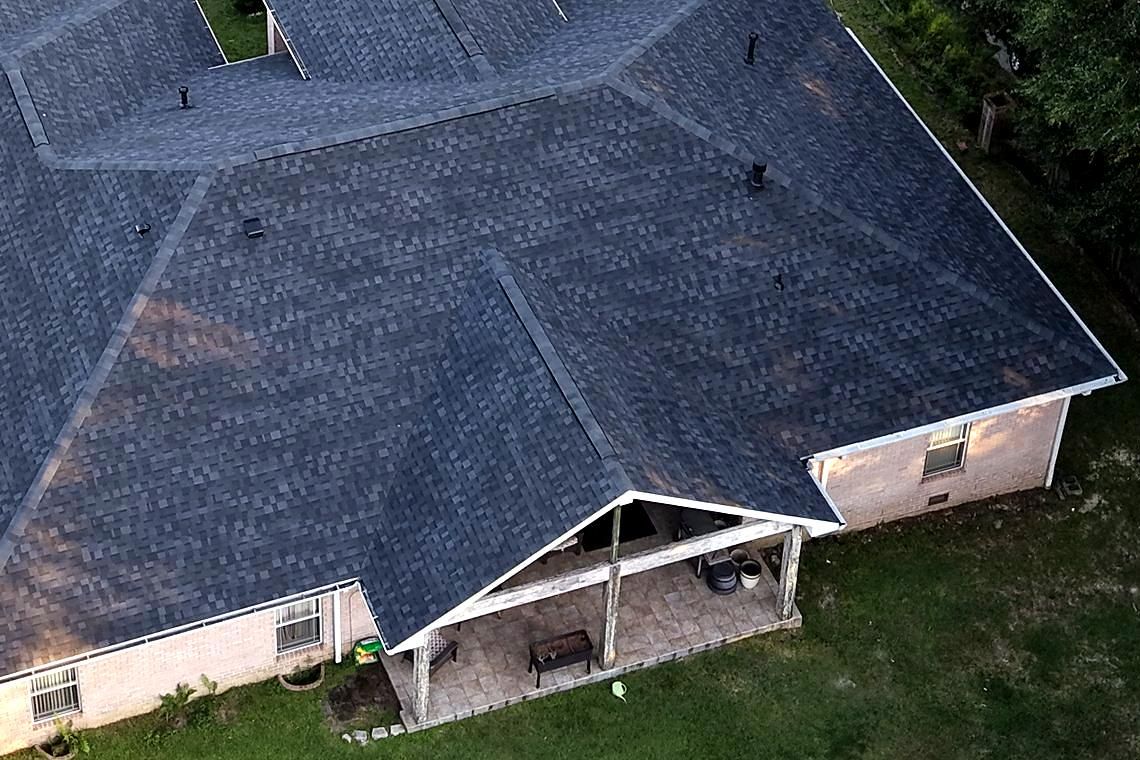 Rear slope and covered patio of a brick home after a full P3 roof replacement