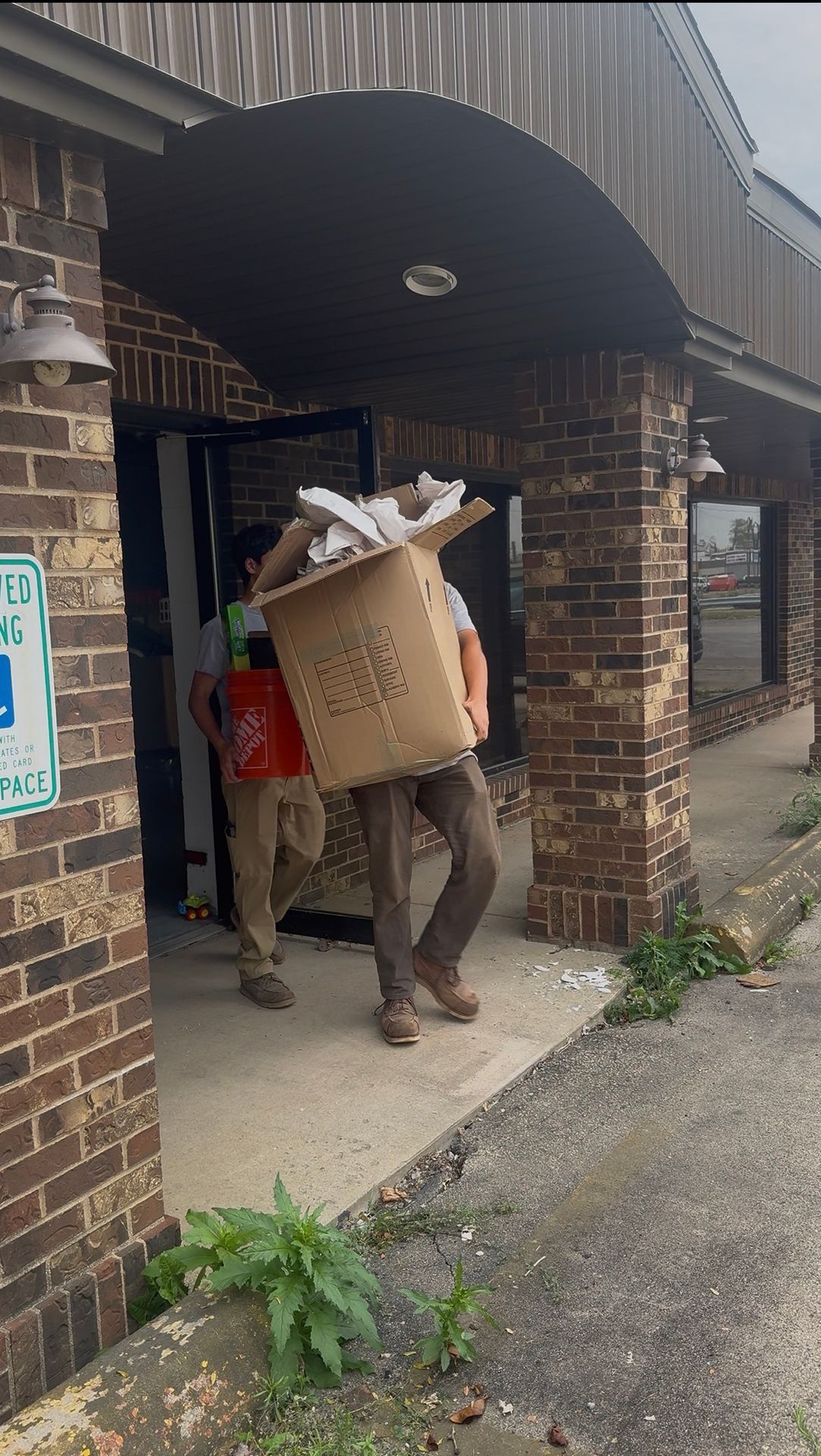 Yard & Beyond Solutions crew carrying a large box out of a building during a cleanout