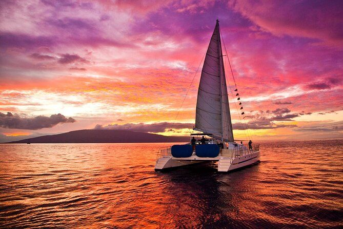 Luxury catamaran sailing across calm ocean waters during a vibrant pink and orange sunset in the Caribbean. Luxury catamaran sailing across calm ocean waters during a vibrant pink and orange sunset in the Caribbean.