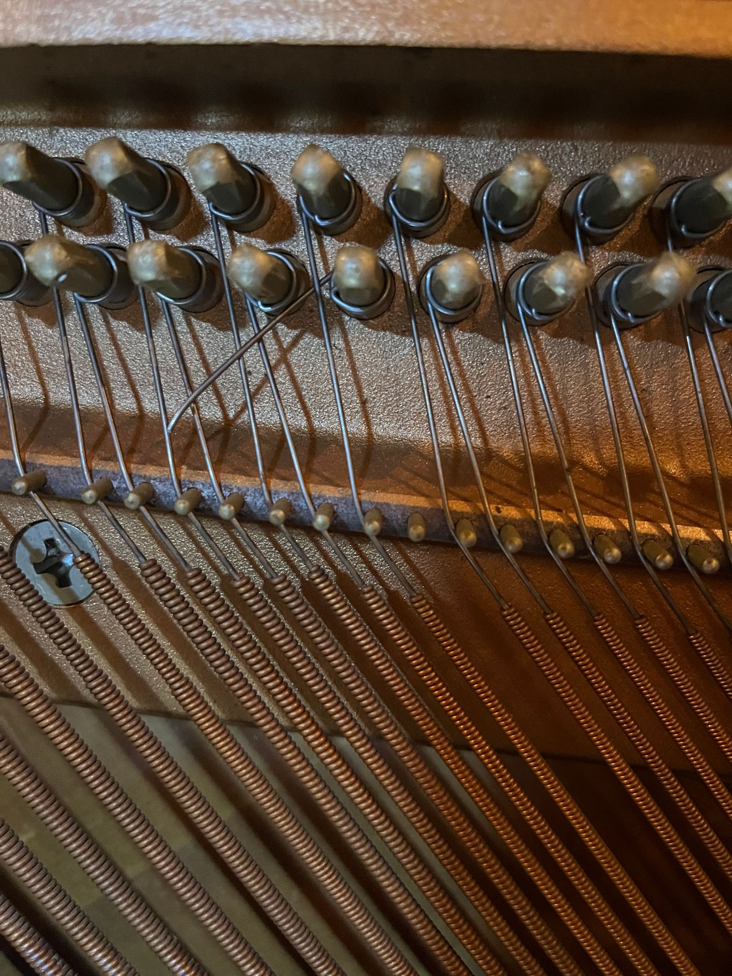 A broken piano bass string inside an upright piano A broken piano bass string inside an upright piano