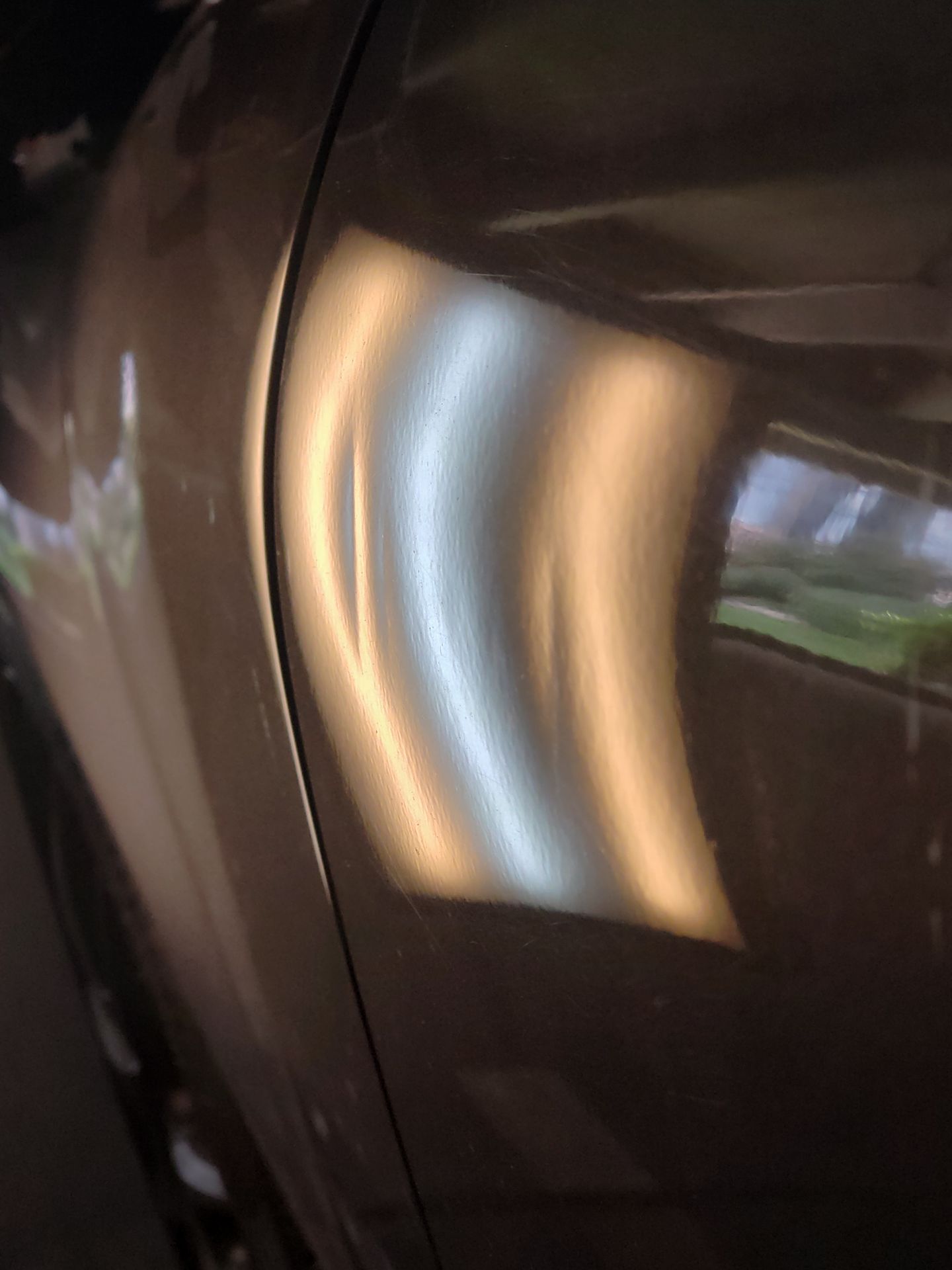 Multiple door dings visible under a professional PDR inspection light