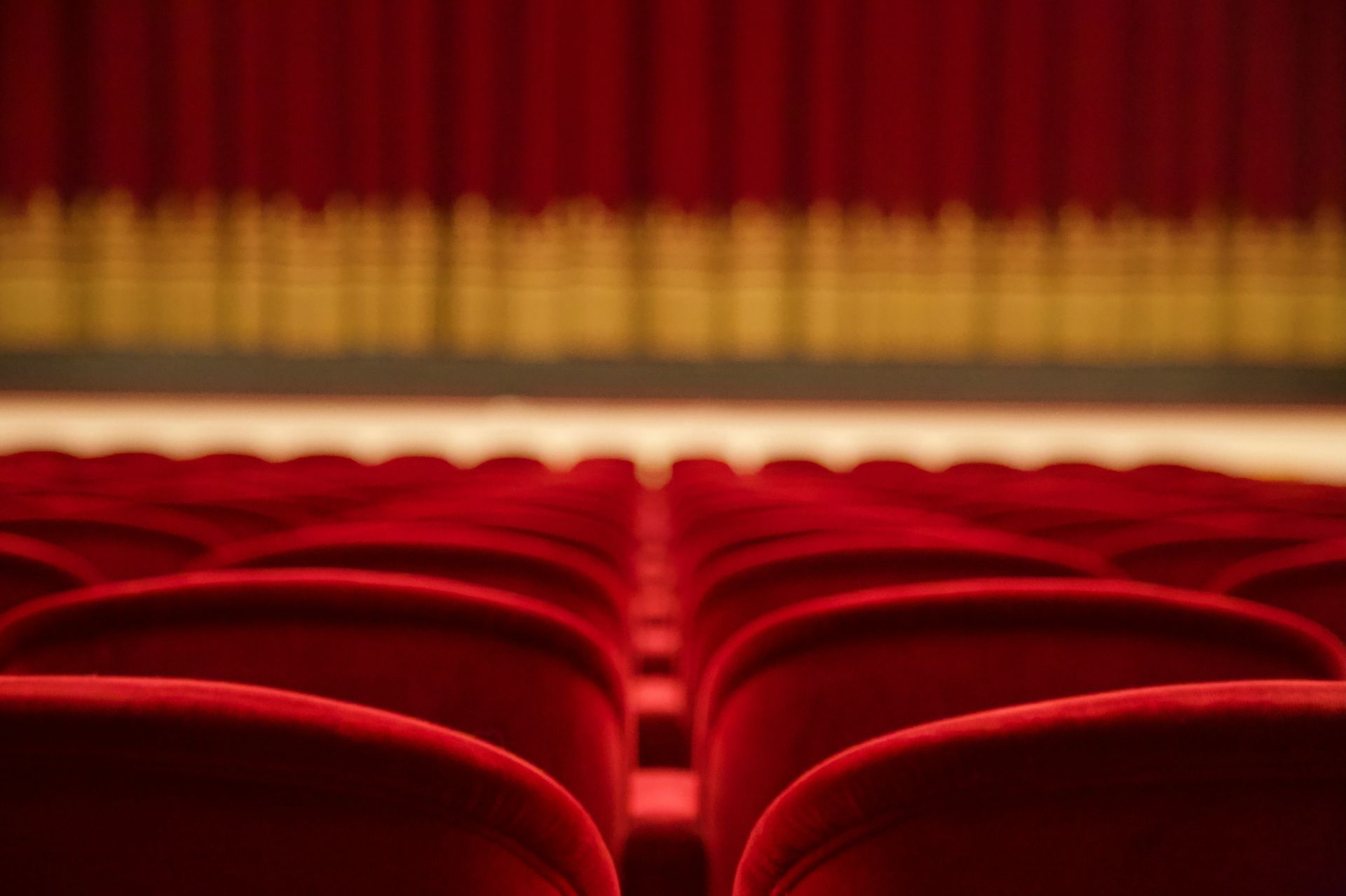 Empty red and white theater seats, representing chaos, burnout, and the theatrical missteps of juggling life and side hustles.