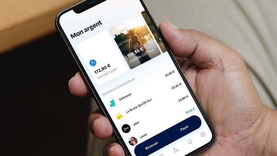 La main d'un homme tiens un smartphone sur une application qui est LYDIA