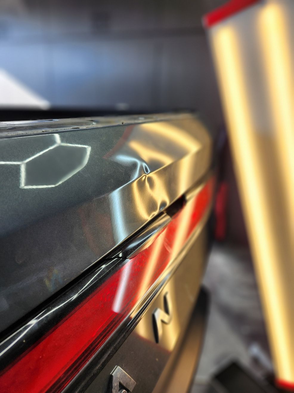 Large body-line dent on an aluminum Rivian tailgate