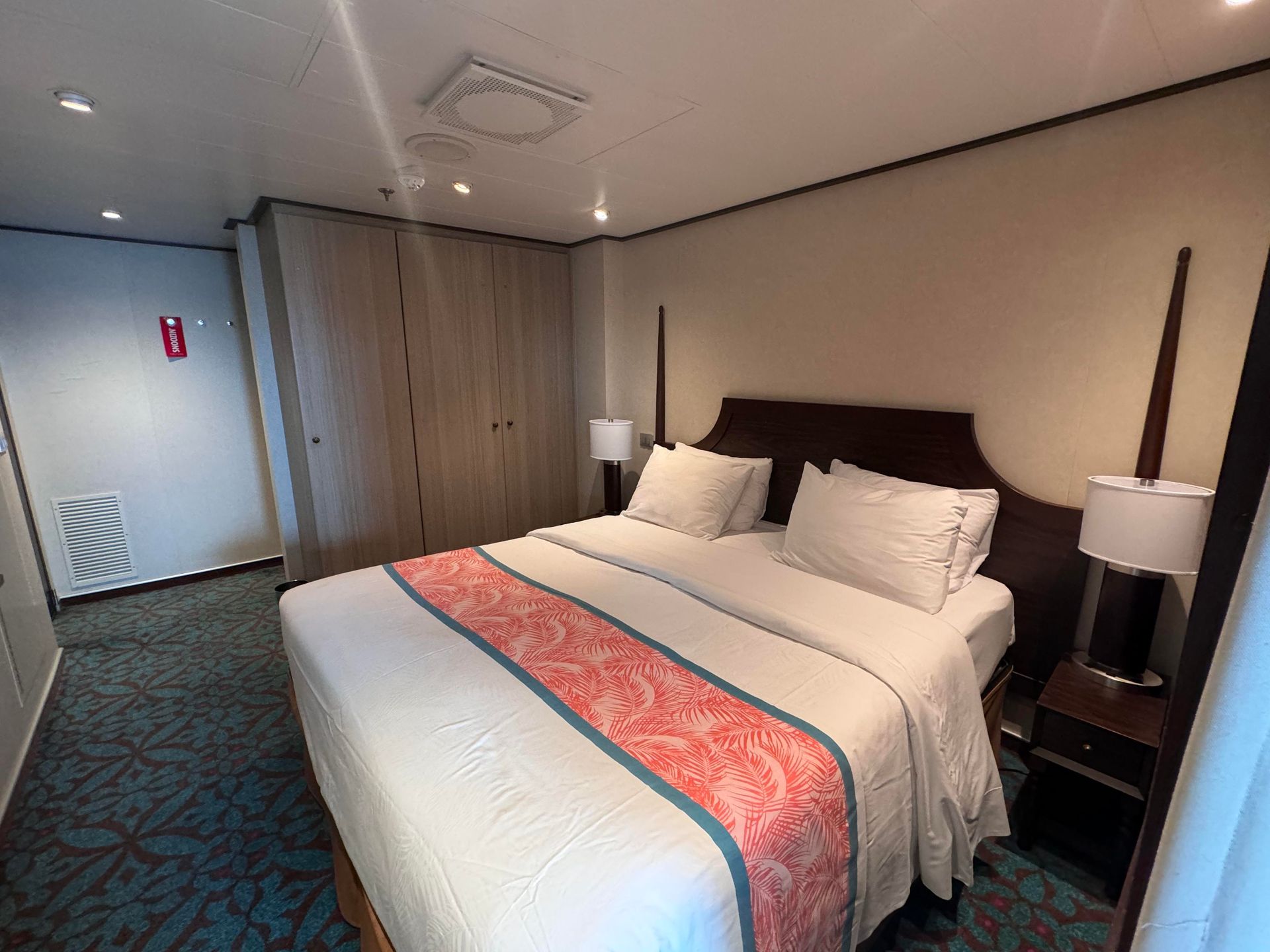 Cozy cruise ship bedroom with a large bed, soft lighting, modern decor, and a tropical-themed runner in a Havana Suite on Carnival Vista. Cozy cruise ship bedroom with a large bed, soft lighting, modern decor, and a tropical-themed runner in a Havana Suite on Carnival Vista.