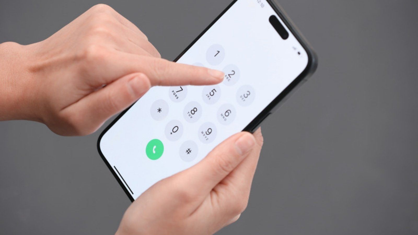 Hands dialling a trusted number on a smartphone to check a suspected voice clone scam phone call