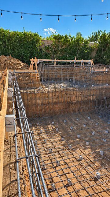 Reinforcing steel outlining a raised spa above an excavated pool