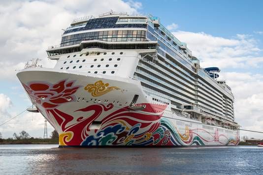 Norwegian Joy cruise ship on the water, featuring colorful red, gold, and blue artwork across its bow.