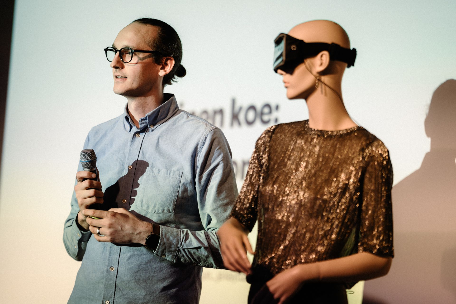 Joona Kotilainen ja hänen rakentama tekoälyrobotti stand up -esityksessä lavalla