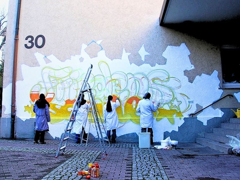 Schüler:innen sprayen beim Graffiti Workshop an der Friedensschule Stuttgart-West