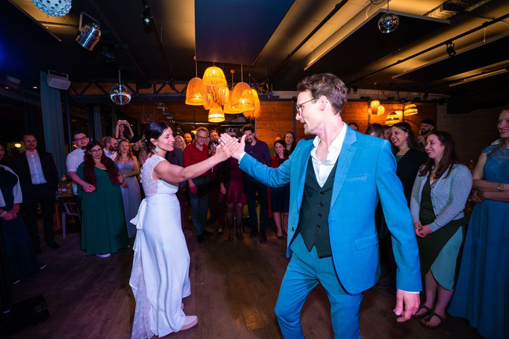 Hochzeitstanz des Brautpaares bei der Feier mit Gästen und Partybeleuchtung