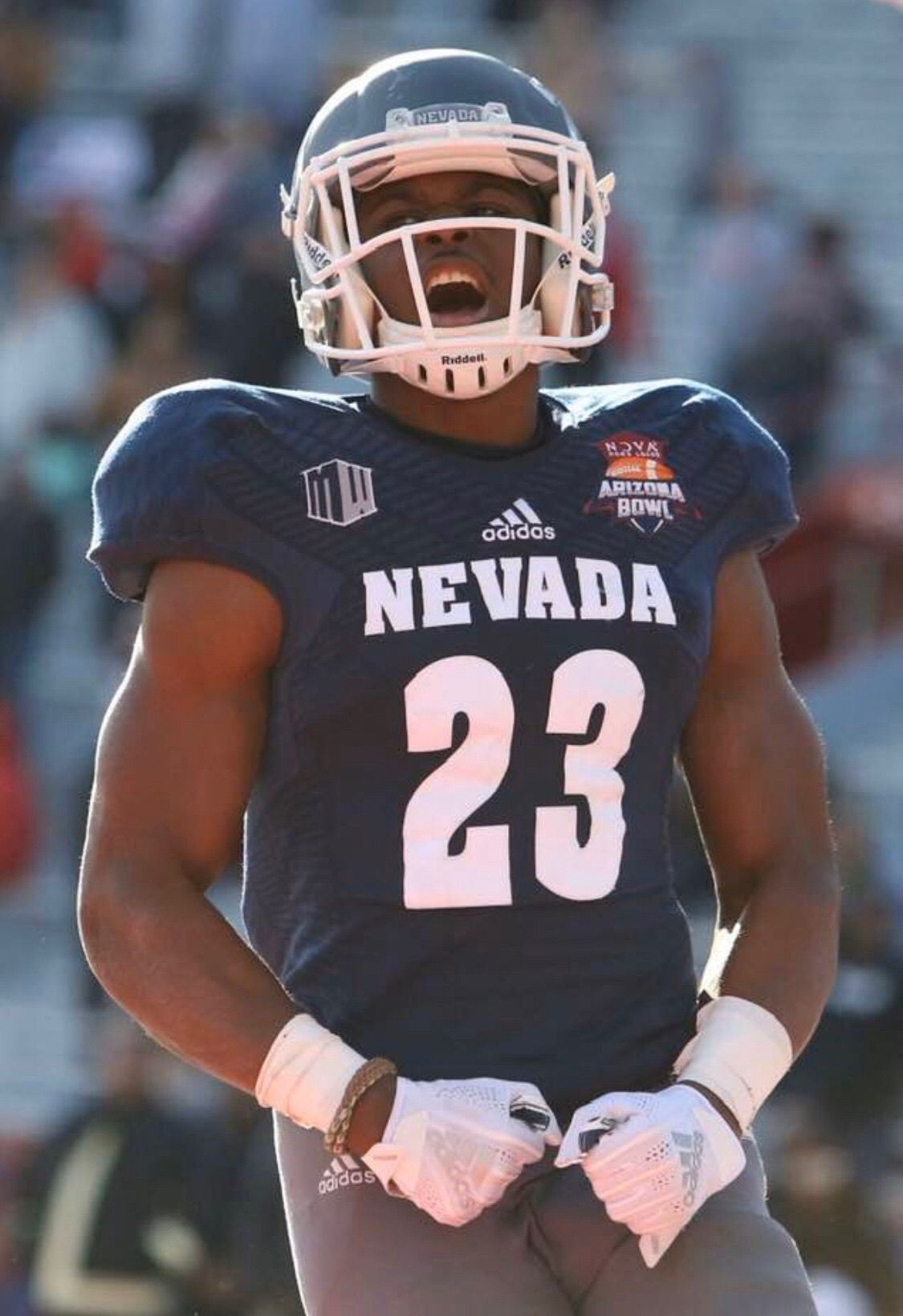Football player in Nevada jersey number 23 celebrating during a game.