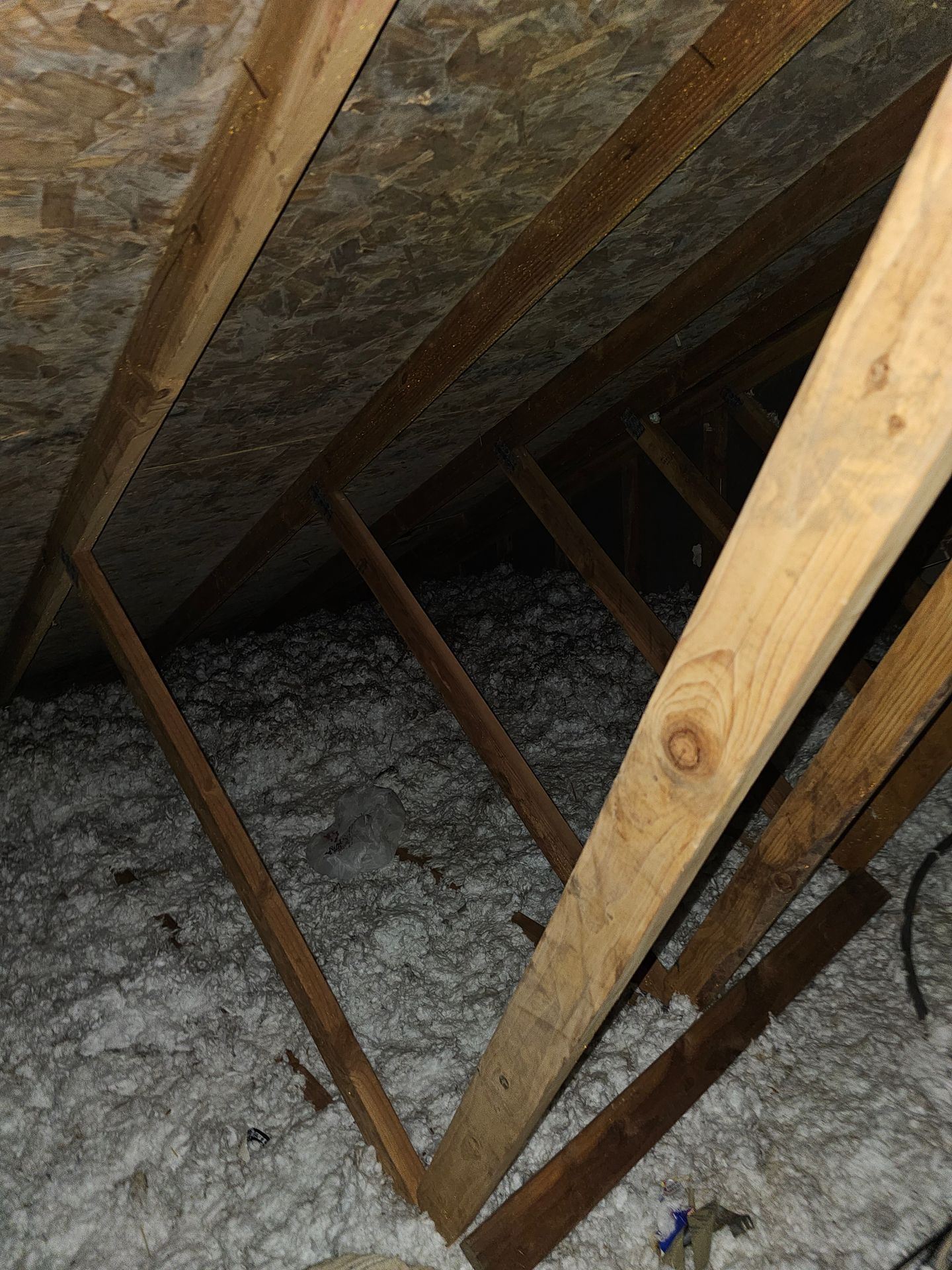 Attic roof decking and wood framing above loose-fill insulation