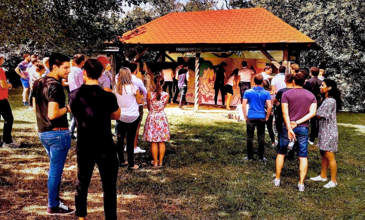 Porsche-Team beim Graffiti Workshop auf dem Grillplatz in Weissach – gemeinsames Gruppenbild mit Coach Open Mike