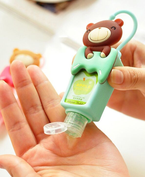 A person dispensing hand sanitizer from a small bottle in a cute teddy bear holder, emphasizing travel hygiene and cleanliness. A person dispensing hand sanitizer from a small bottle in a cute teddy bear holder, emphasizing travel hygiene and cleanliness.