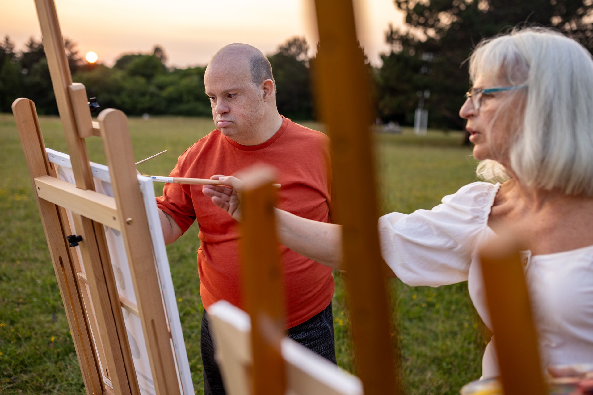 a woman standing next to a man in a wheel chair a woman standing next to a man in a wheel chair