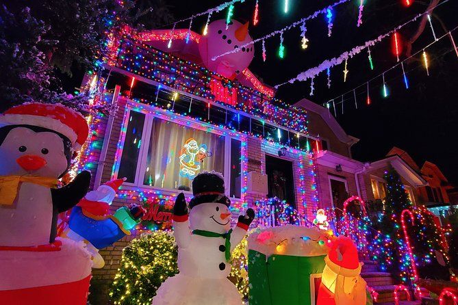 House decorated with colorful Christmas lights and inflatable snowmen and penguins, glowing brightly at night. House decorated with colorful Christmas lights and inflatable snowmen and penguins, glowing brightly at night.
