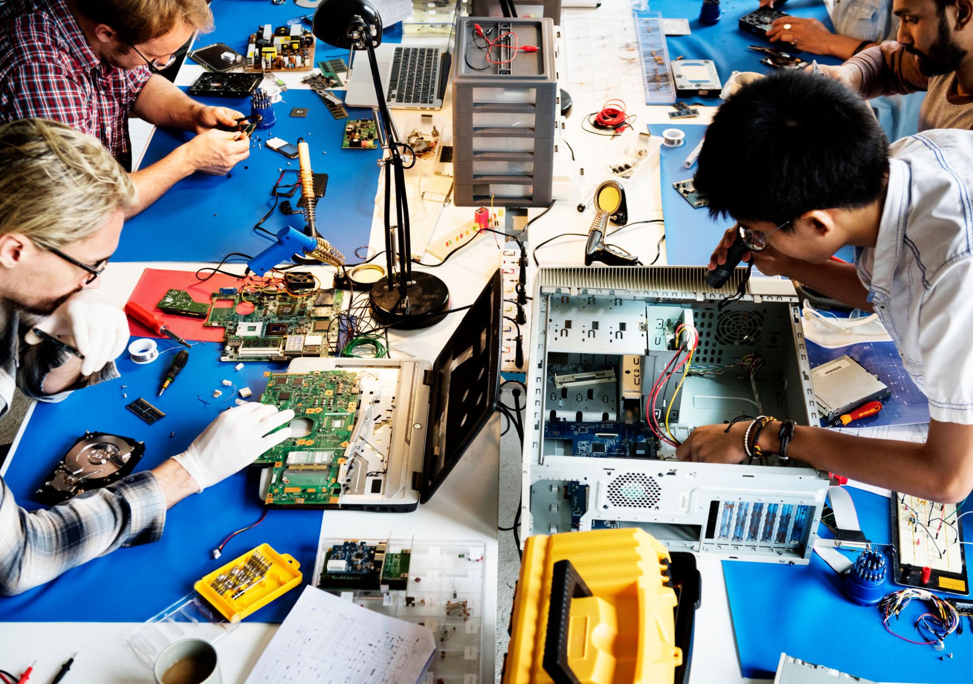 Electronics technicians team working on computer parts Electronics technicians team working on computer parts