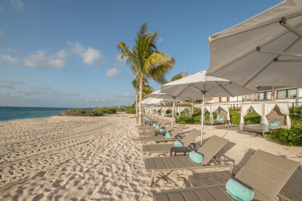 Quiet Playa Delfines beach with lounge chairs, umbrellas, and cabanas. Quiet Playa Delfines beach with lounge chairs, umbrellas, and cabanas.