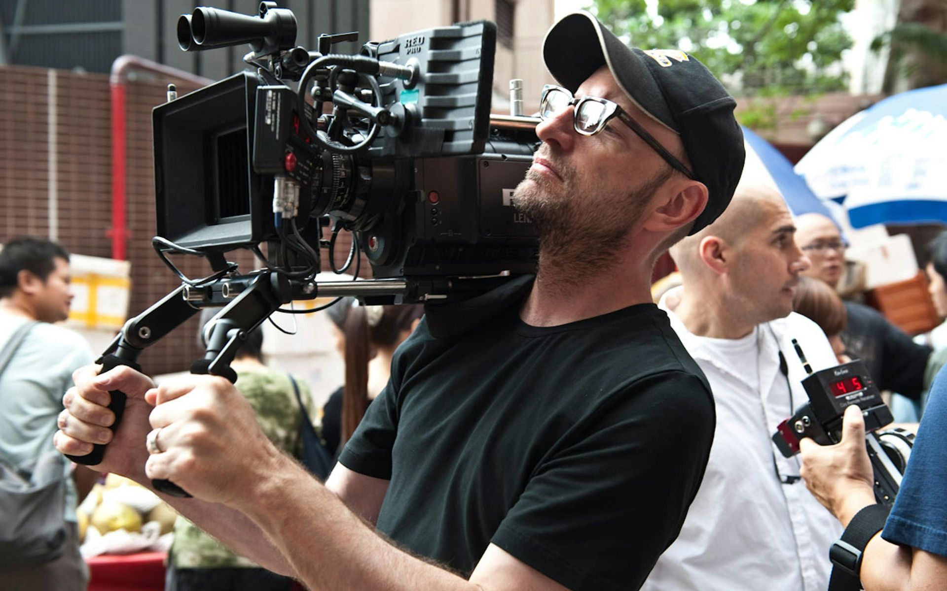 Steven Soderbergh tenant une caméra lors d'un tournage d'un film.