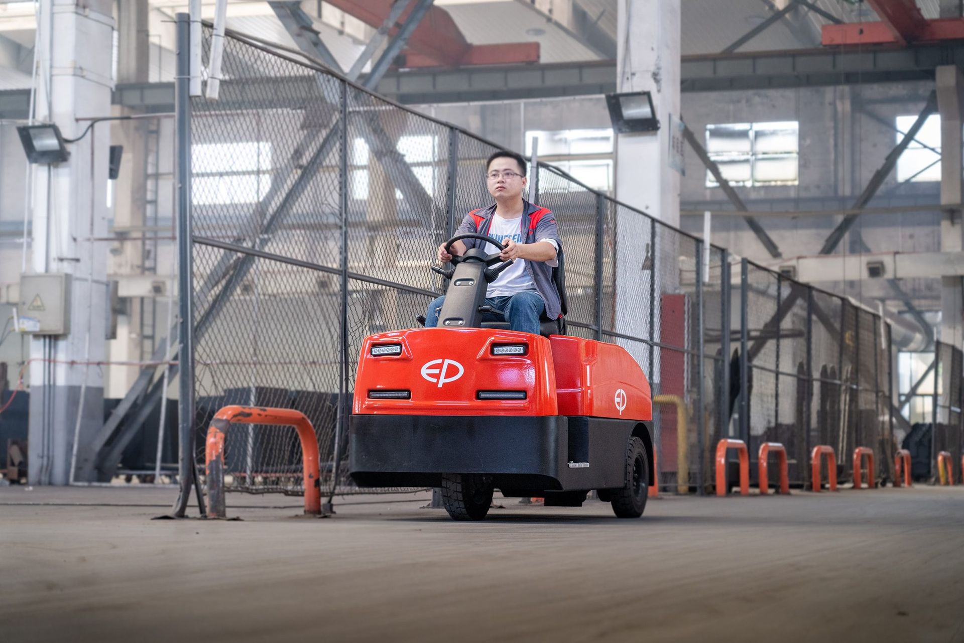 Tow tractor operating in an industrial warehouse
