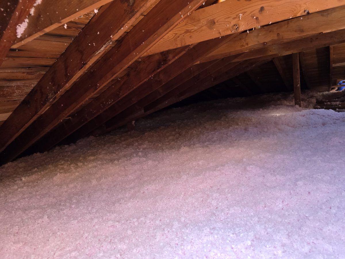 Attic filled with new pink AttiCat blown-in insulation by MichConn