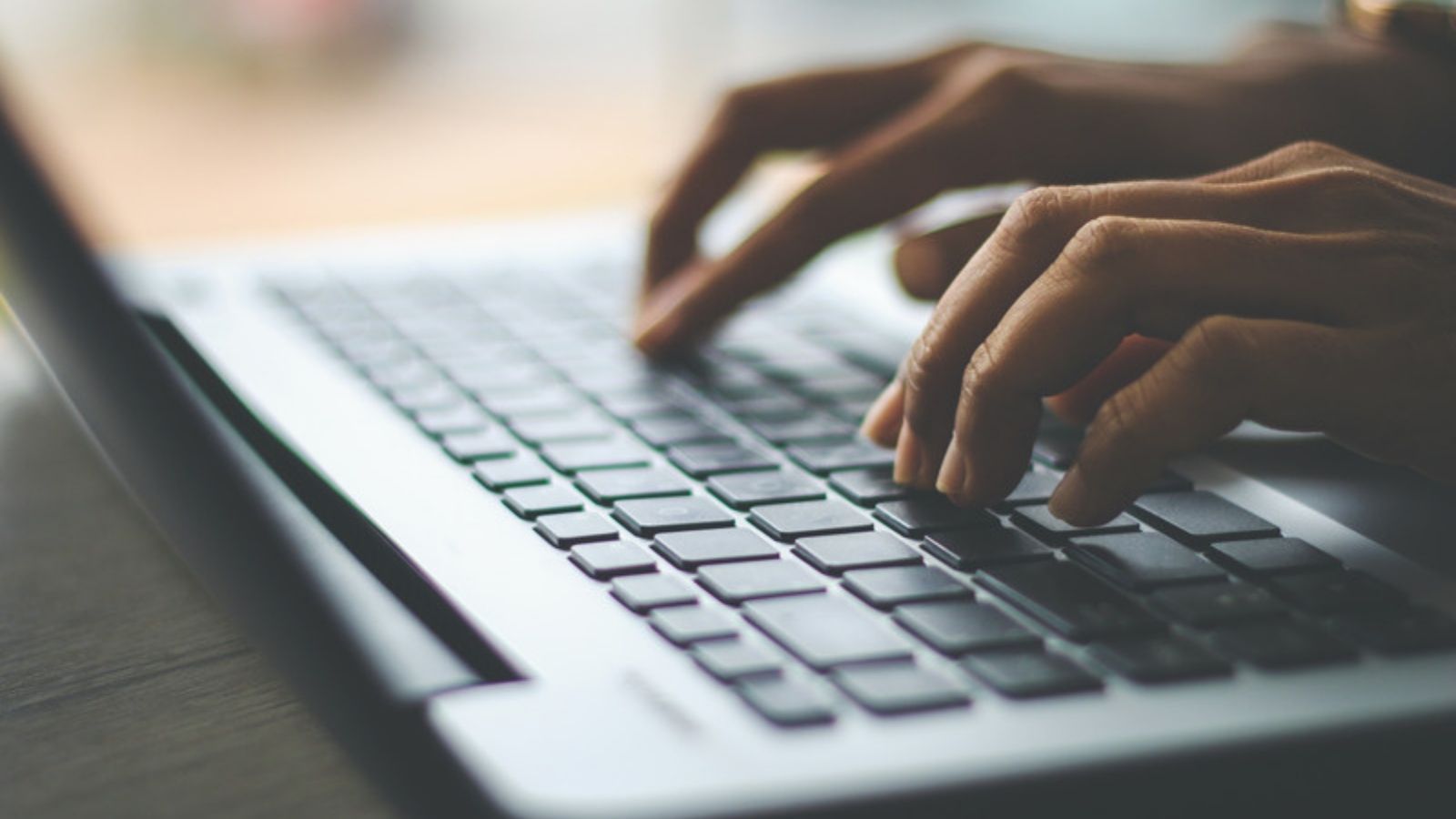 Hands typing a password on a laptop keyboard, How to Set Up Two-Factor Authentication (The Way I Do It)
