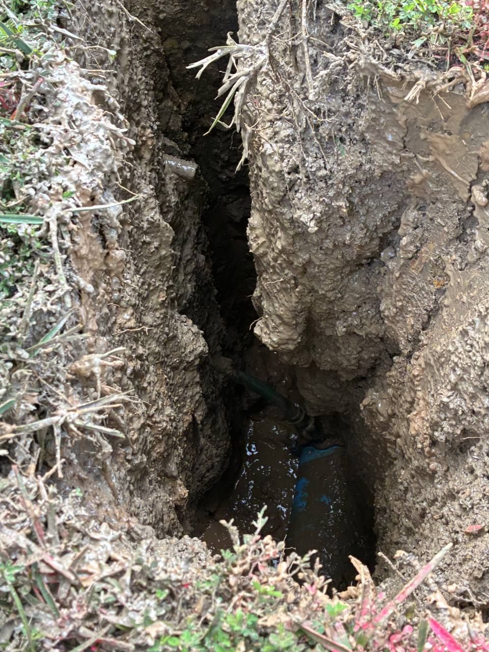 Potholing exposes a buried utility line in a deep excavation before digging continues Potholing exposes a buried utility line in a deep excavation before digging continues