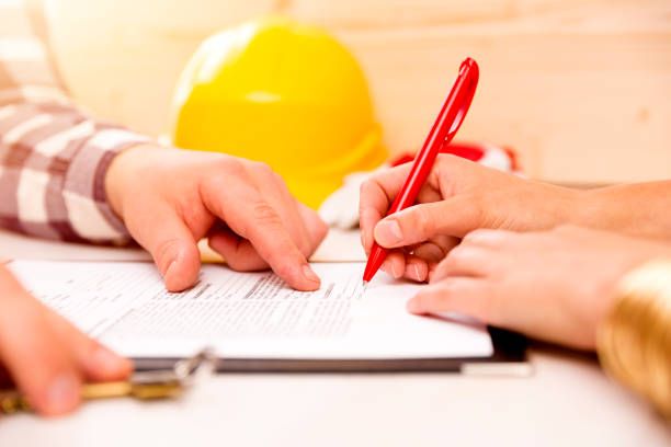Two technicians in safety gear inspecting residential roof surfaces and seals for water damage prevention Two technicians in safety gear inspecting residential roof surfaces and seals for water damage prevention