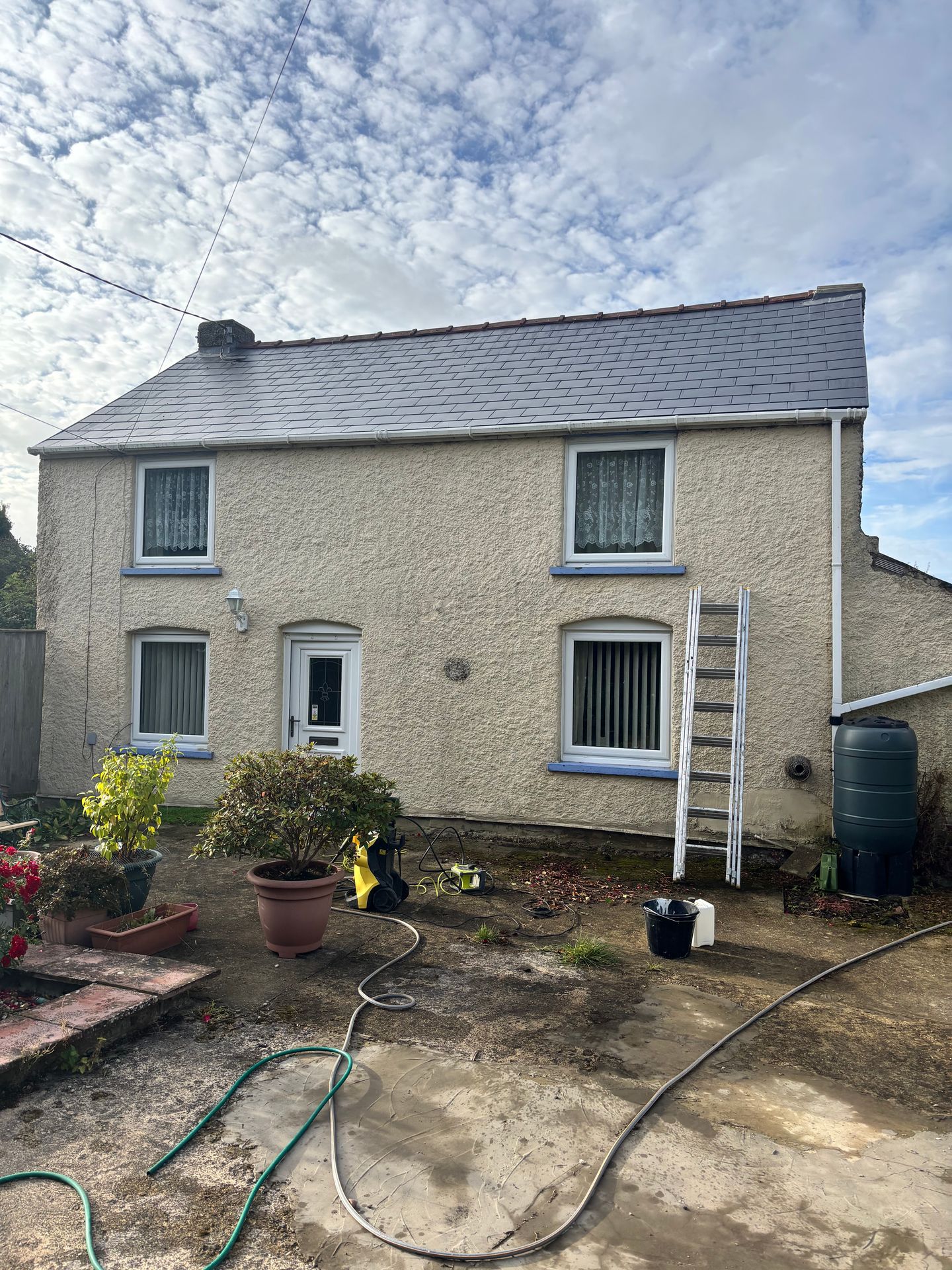 House in Emneth before exterior painting with Sandtex Cornish Cream, showing weathered walls.