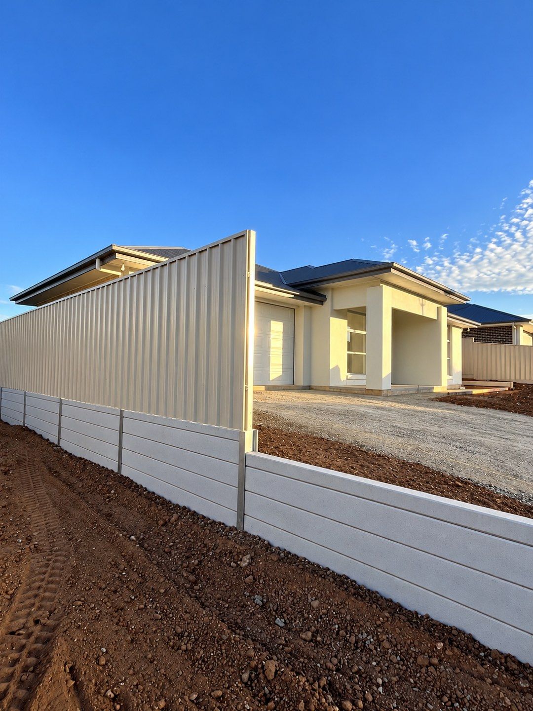 Concrete sleeper retaining wall beside a new home