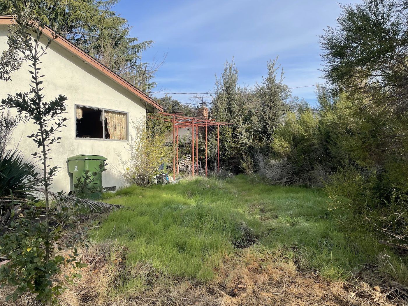 Fremont project, photo 01: Overgrown exterior before rehabilitation
