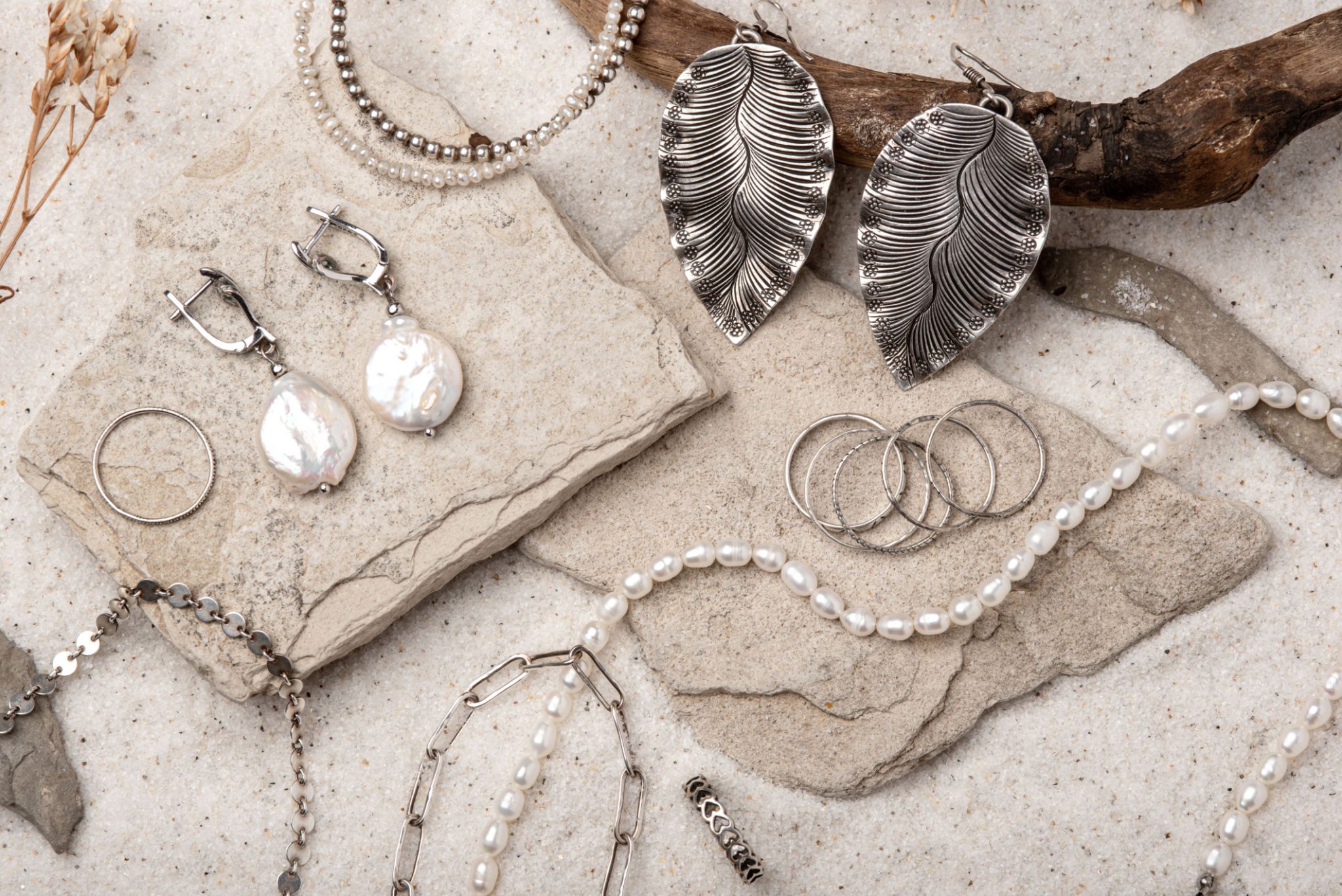 Beautiful Silver and Pearl Jewelry on white sand. Beautiful Silver and Pearl Jewelry on white sand.