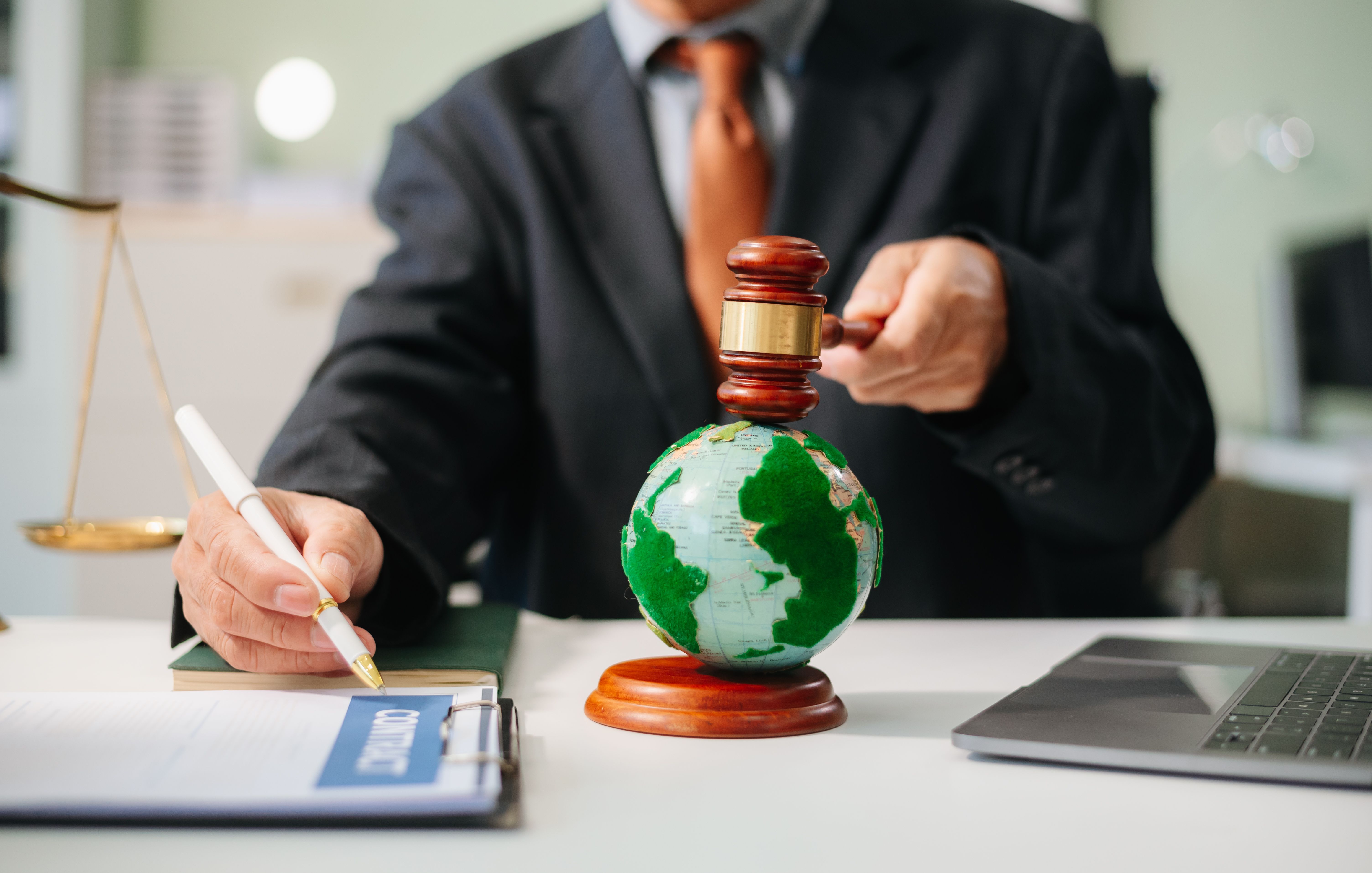 Lawyer making a legal decision with a gavel over a globe, symbolizing global business agreements, justice, and international law.