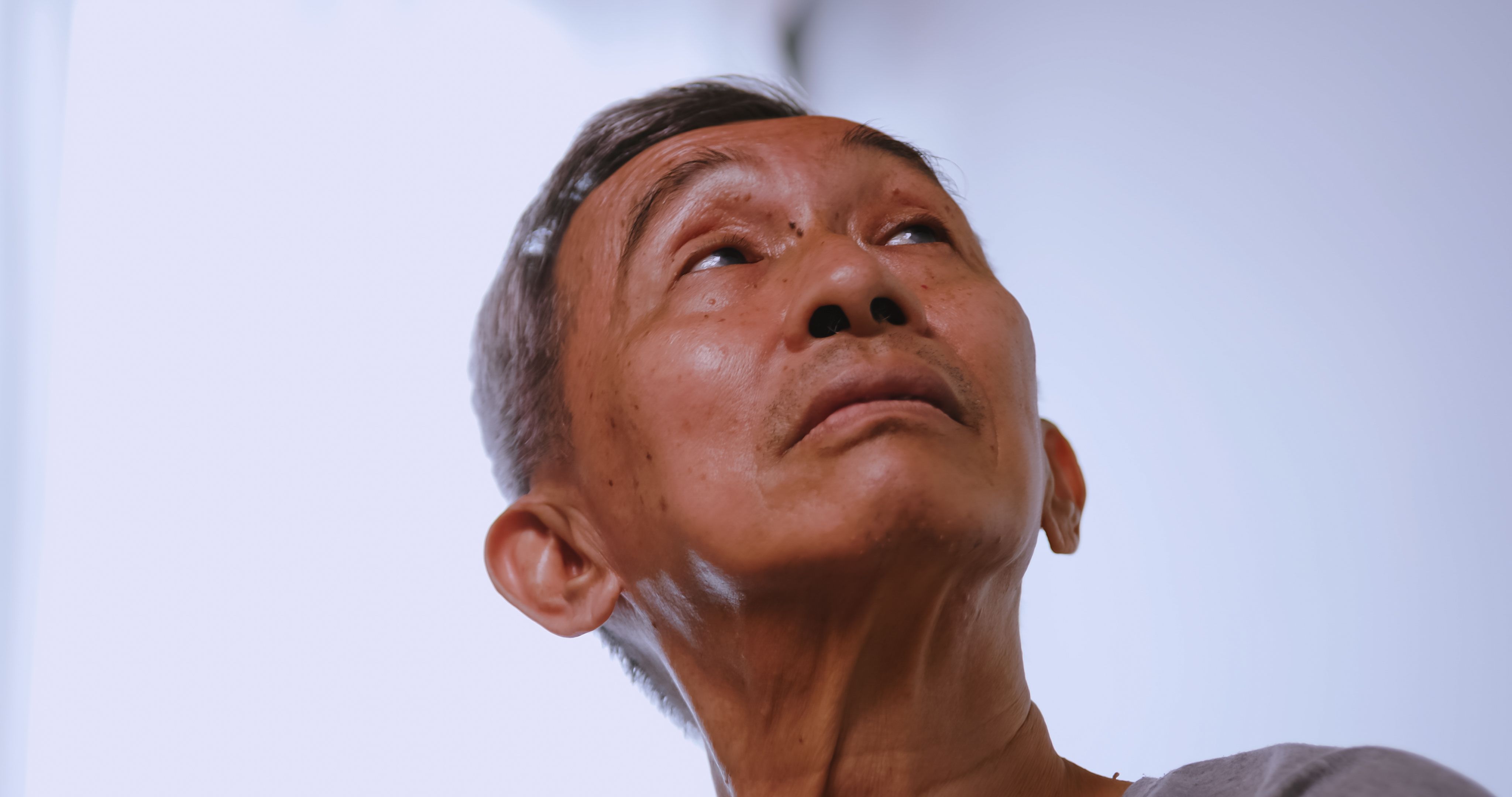 Asian old man with Alzheimer's disease sitting at home alone.