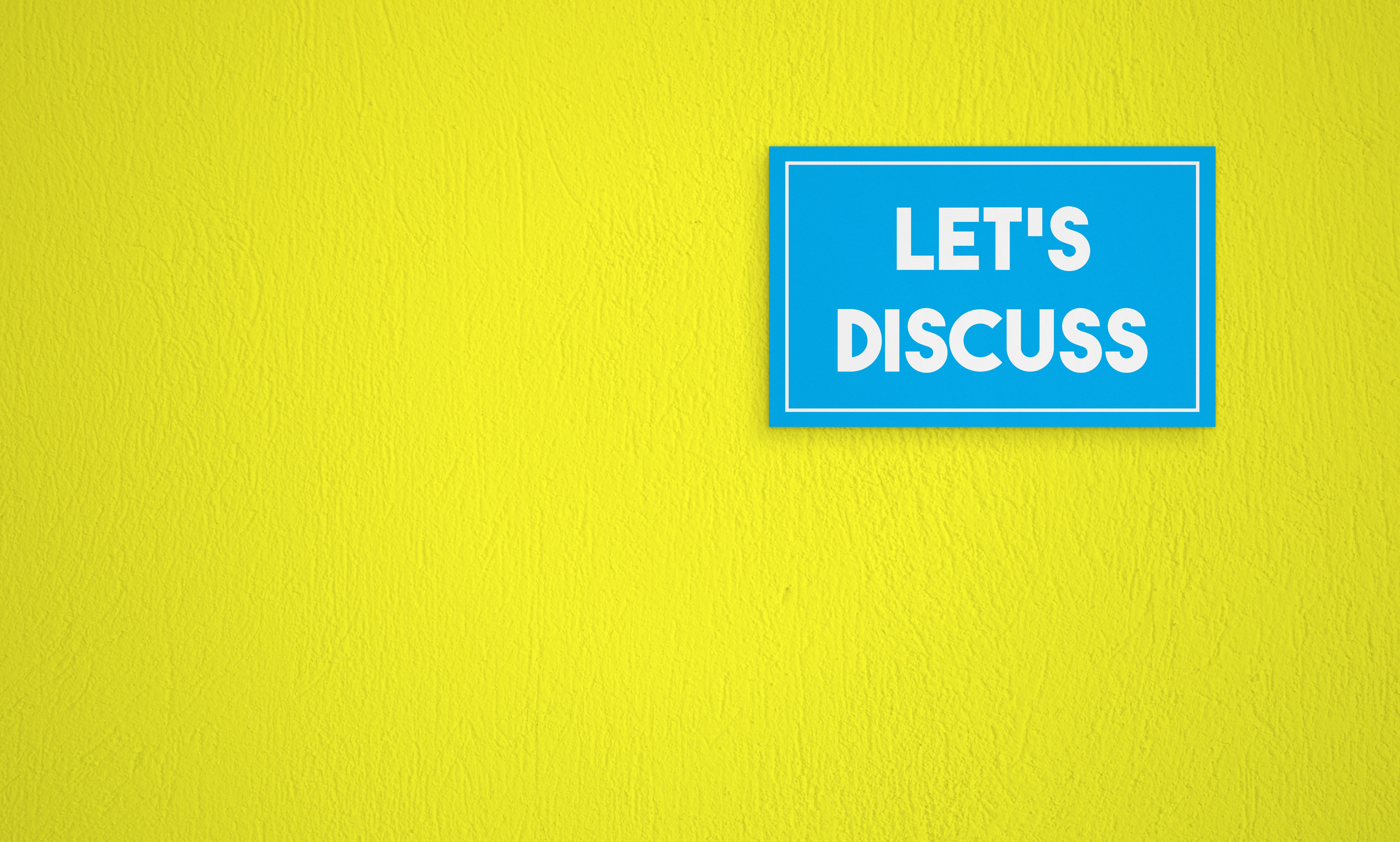 Let’s Discuss Directional Sign On The Yellow Wall Background