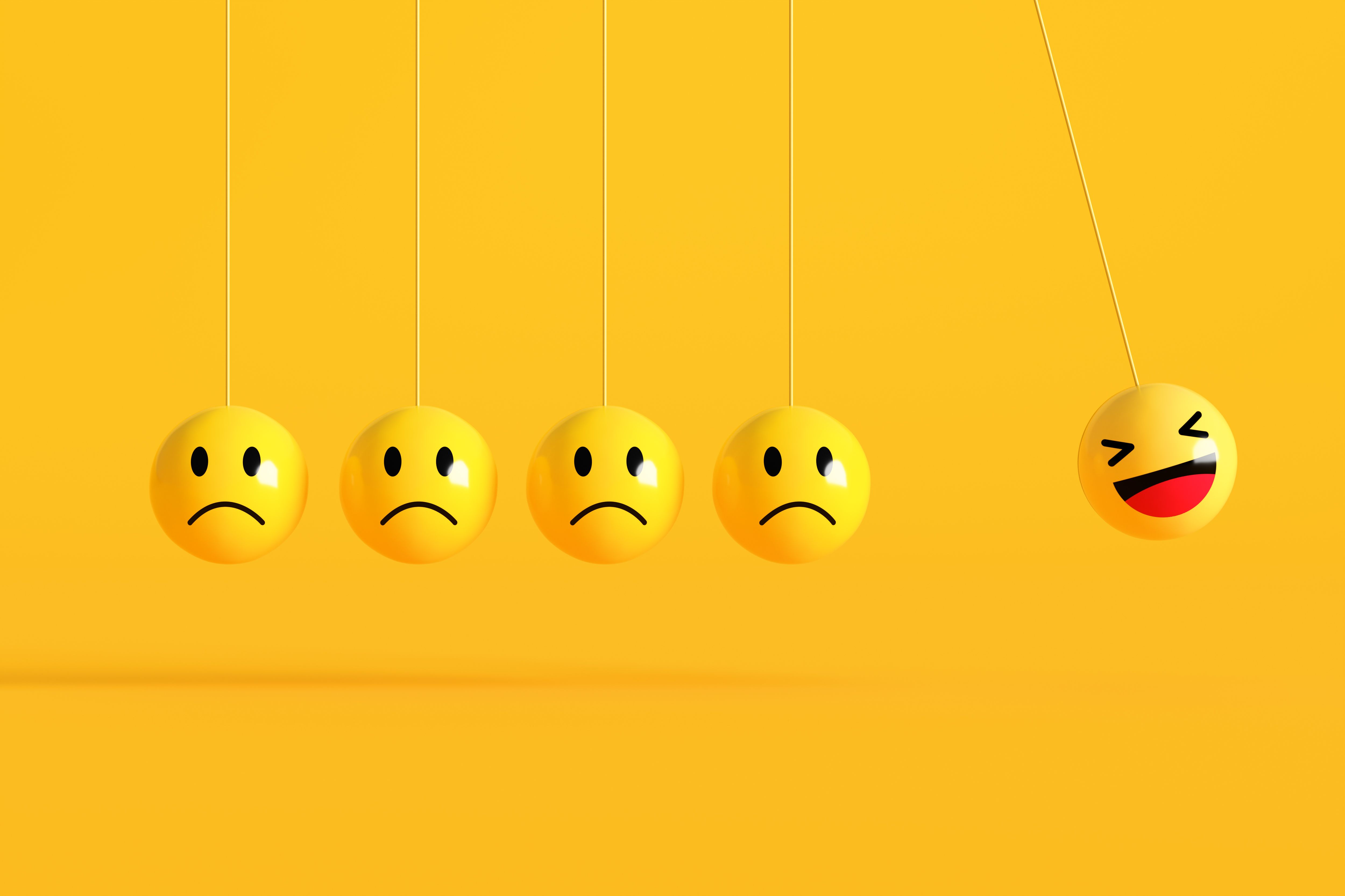 One happy emoji swinging away from sad emojis on yellow background