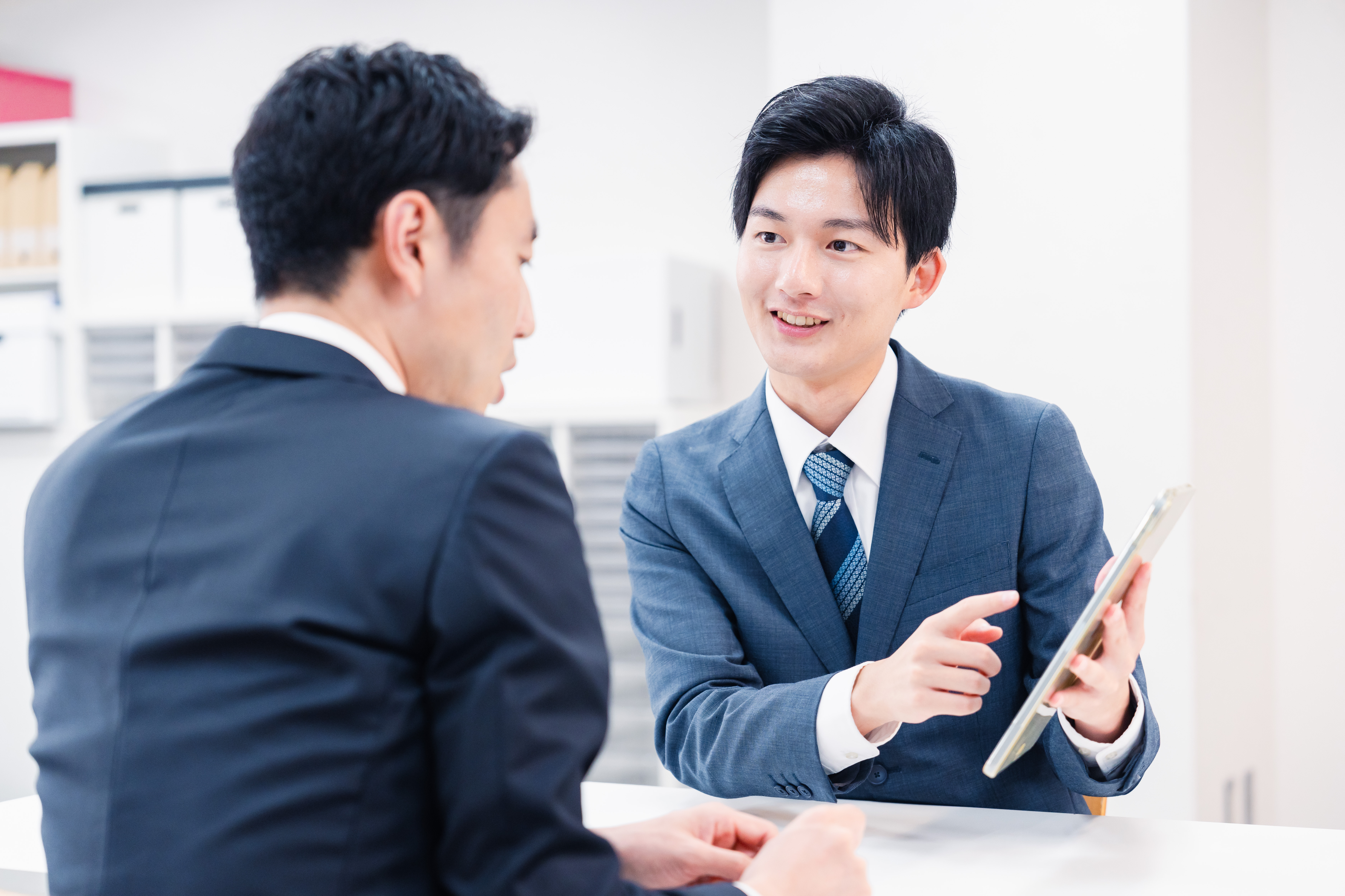 Businessman using a tablet terminal to explain at the counter.