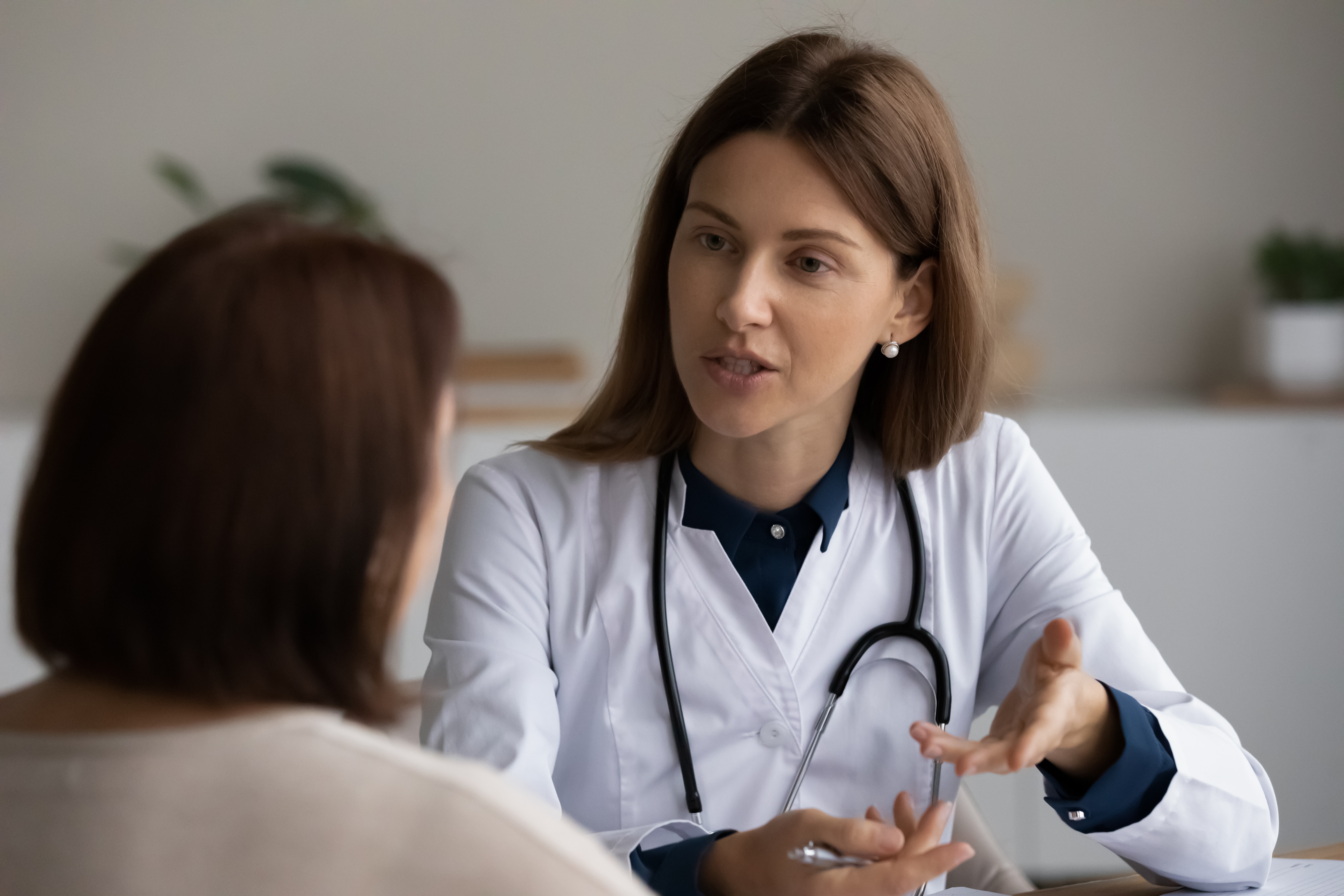 Young female physician asking older patient about complaints Young female physician asking older patient about complaints