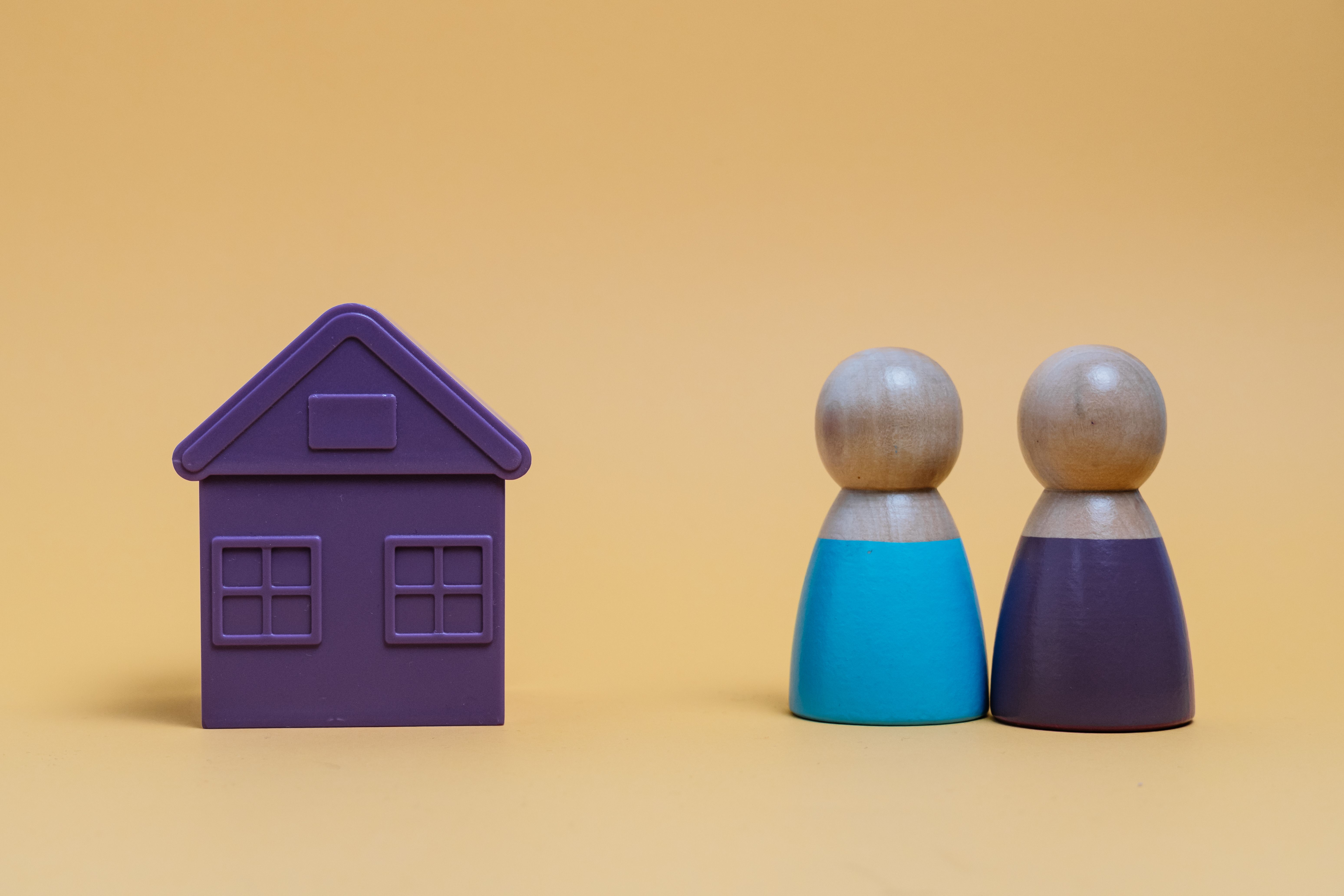 Couple looking at miniature house representing housing market