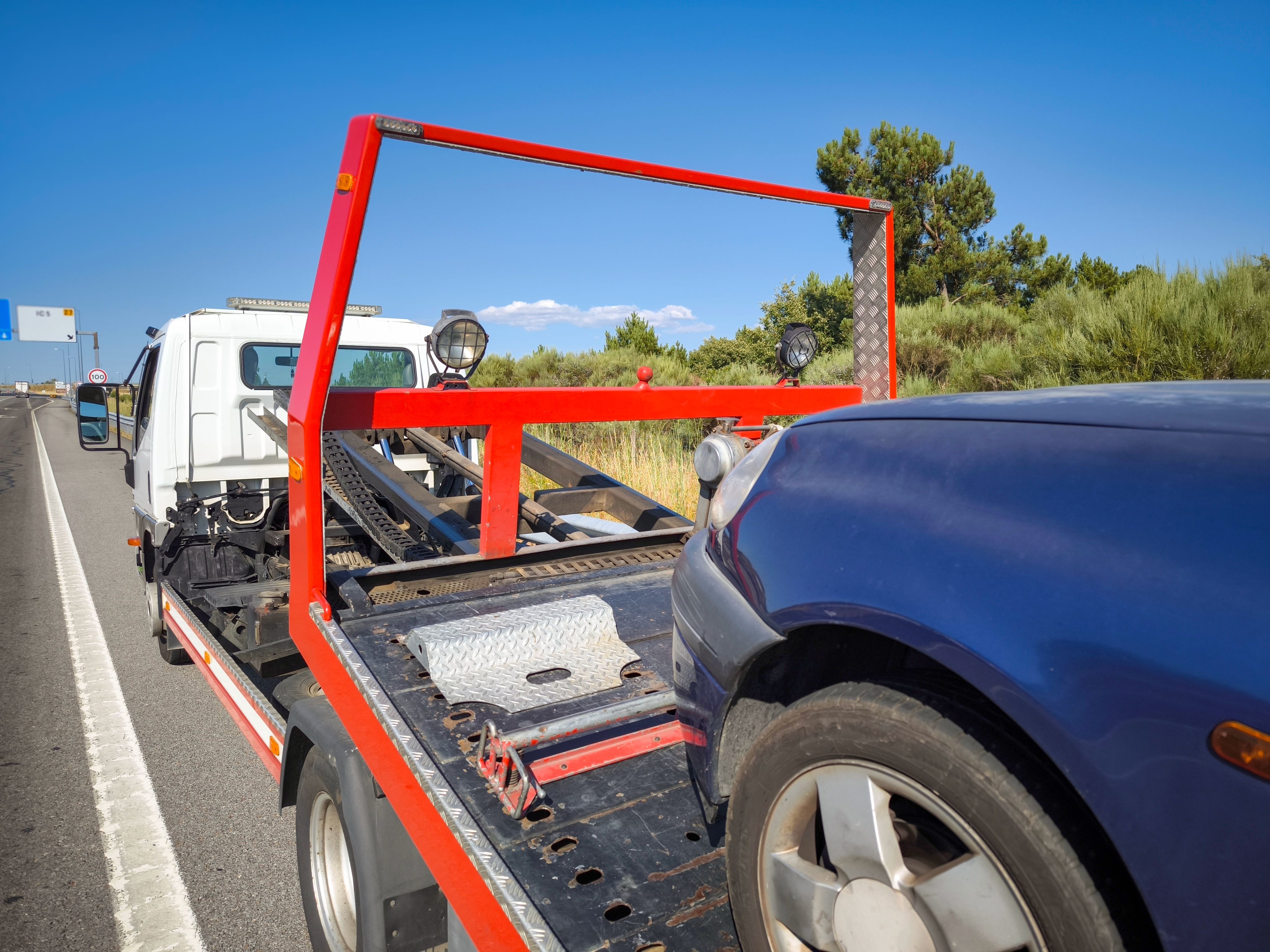 Broken down car being loaded onto a trailer