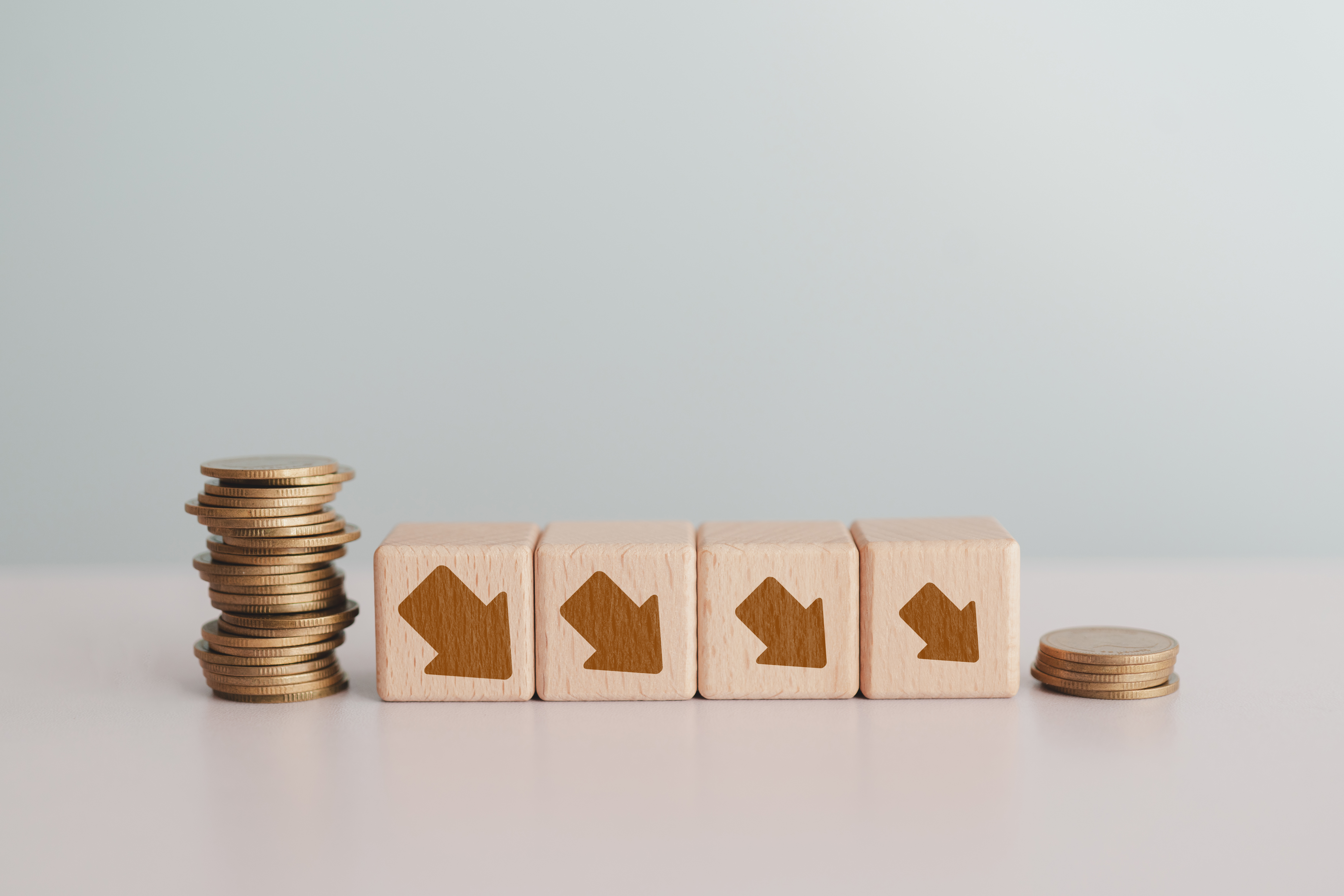 For economic crisis, Inflation. The recession of the economy. Stacks of coins with down arrow on wooden cube blocks including copy space