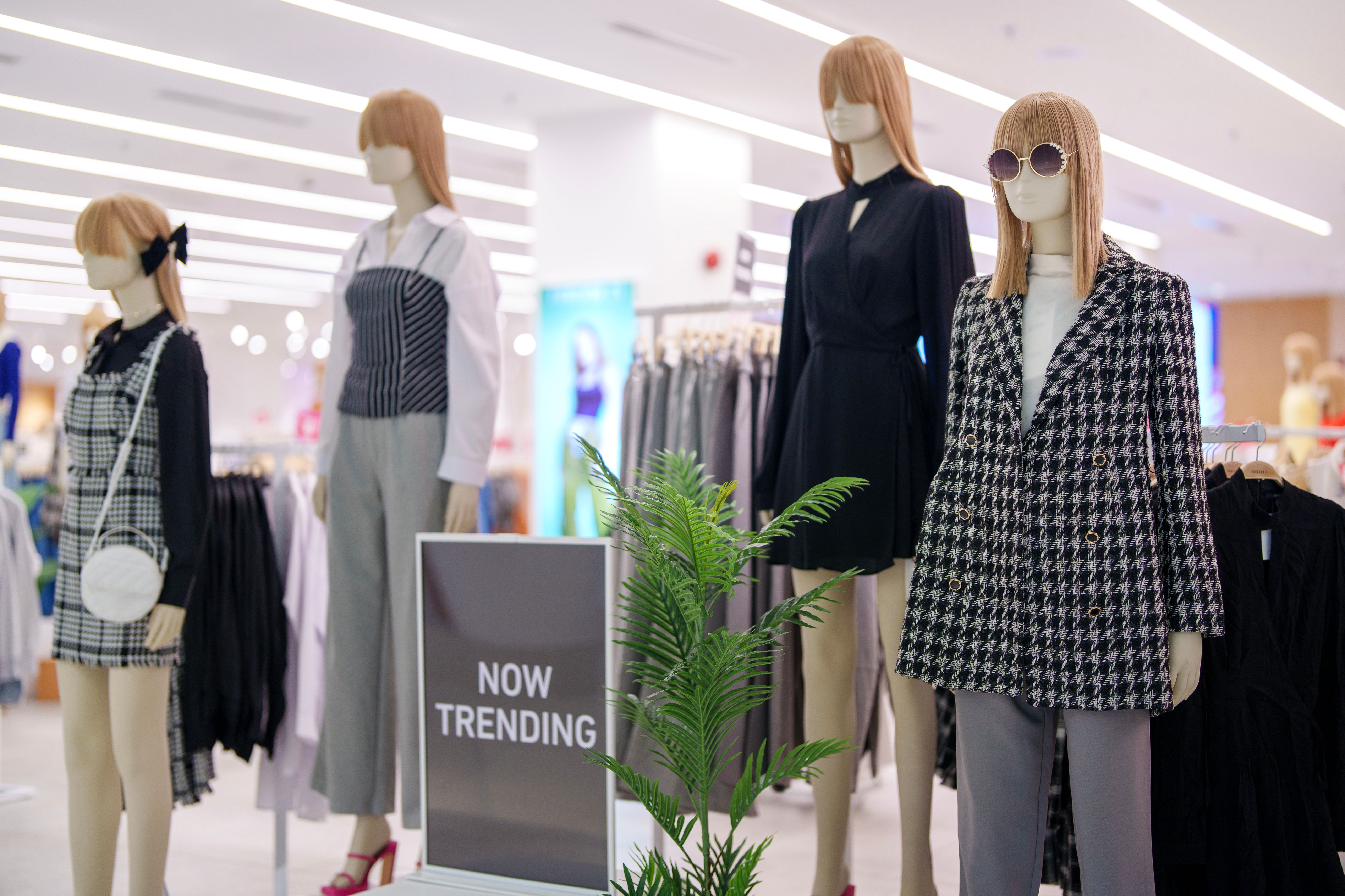A cropped shot of women's clothing elegantly displayed on mannequins in a boutique.