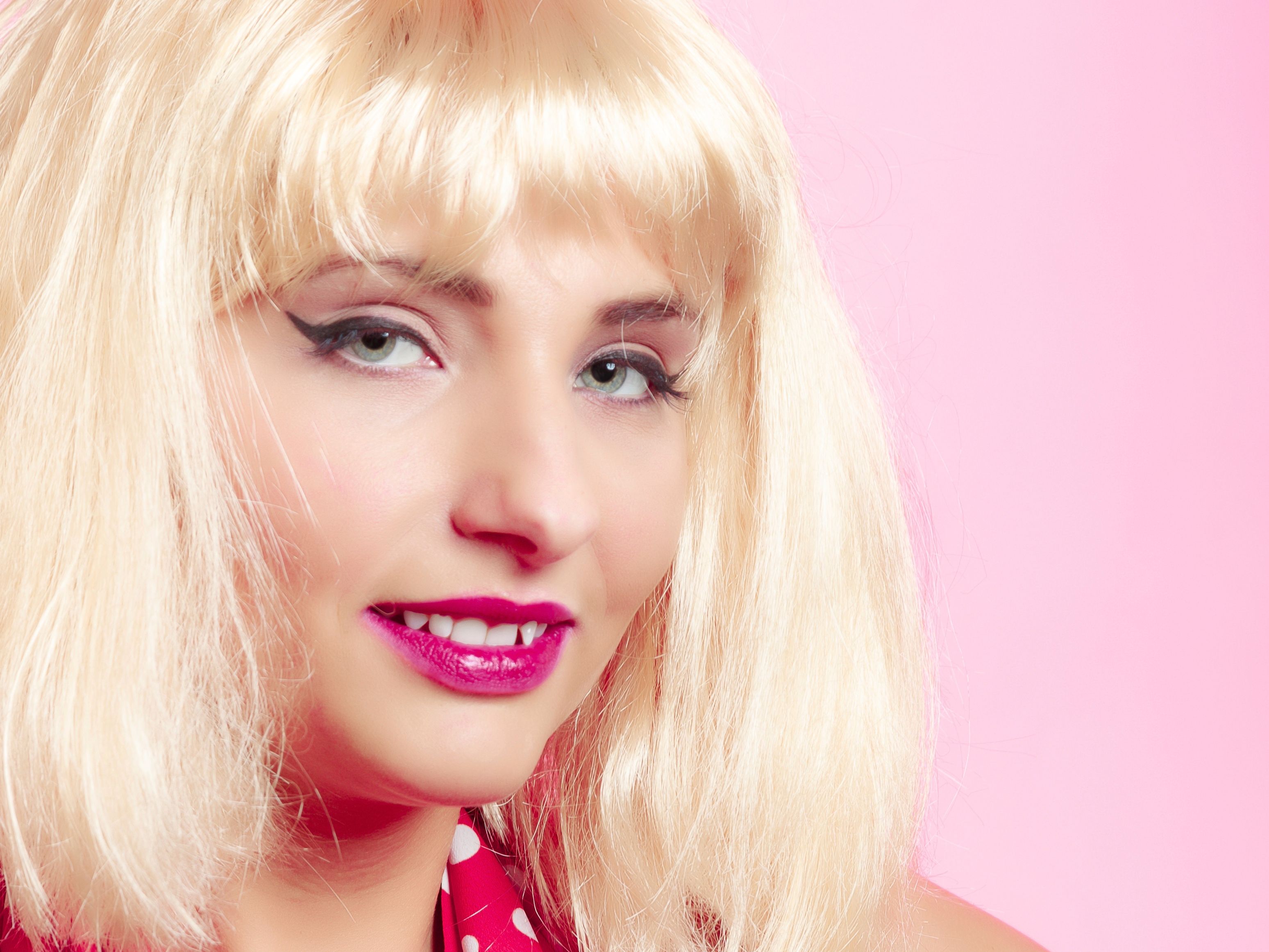 Portrait beautiful pinup girl in blond wig retro red dress