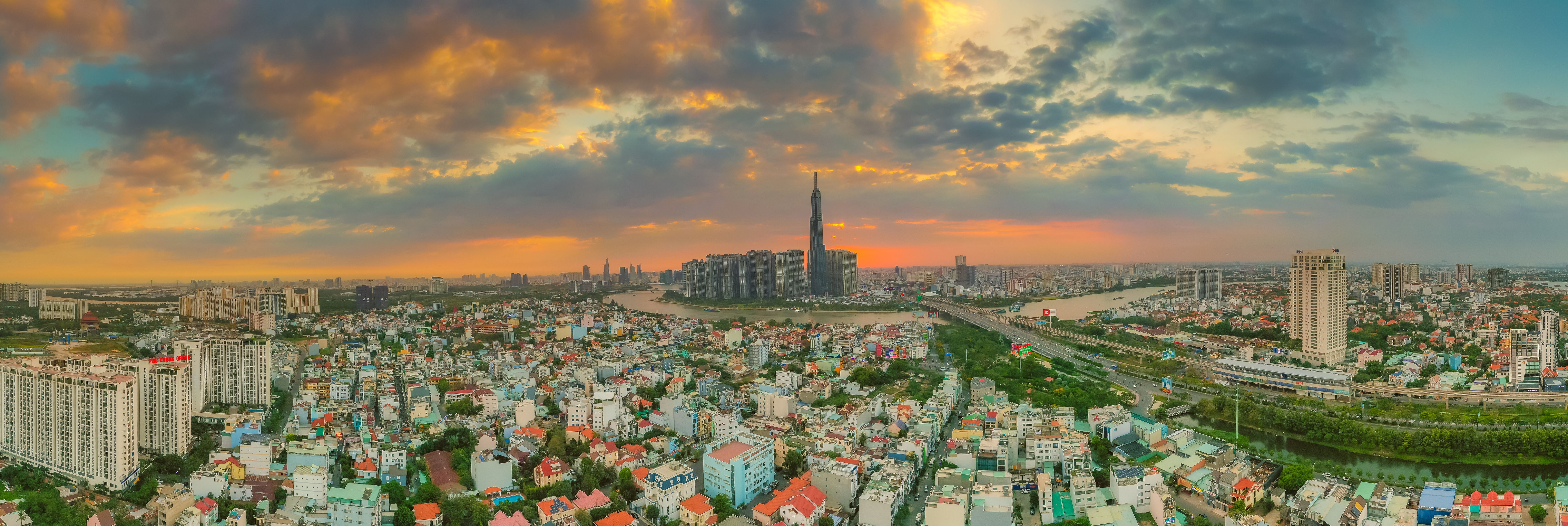Aerial sunset view at Landmark 81 - it is a super tall skyscraper and Saigon bridge with development buildings along Saigon river light smooth down. Aerial sunset view at Landmark 81 - it is a super tall skyscraper and Saigon bridge with development buildings along Saigon river light smooth down.